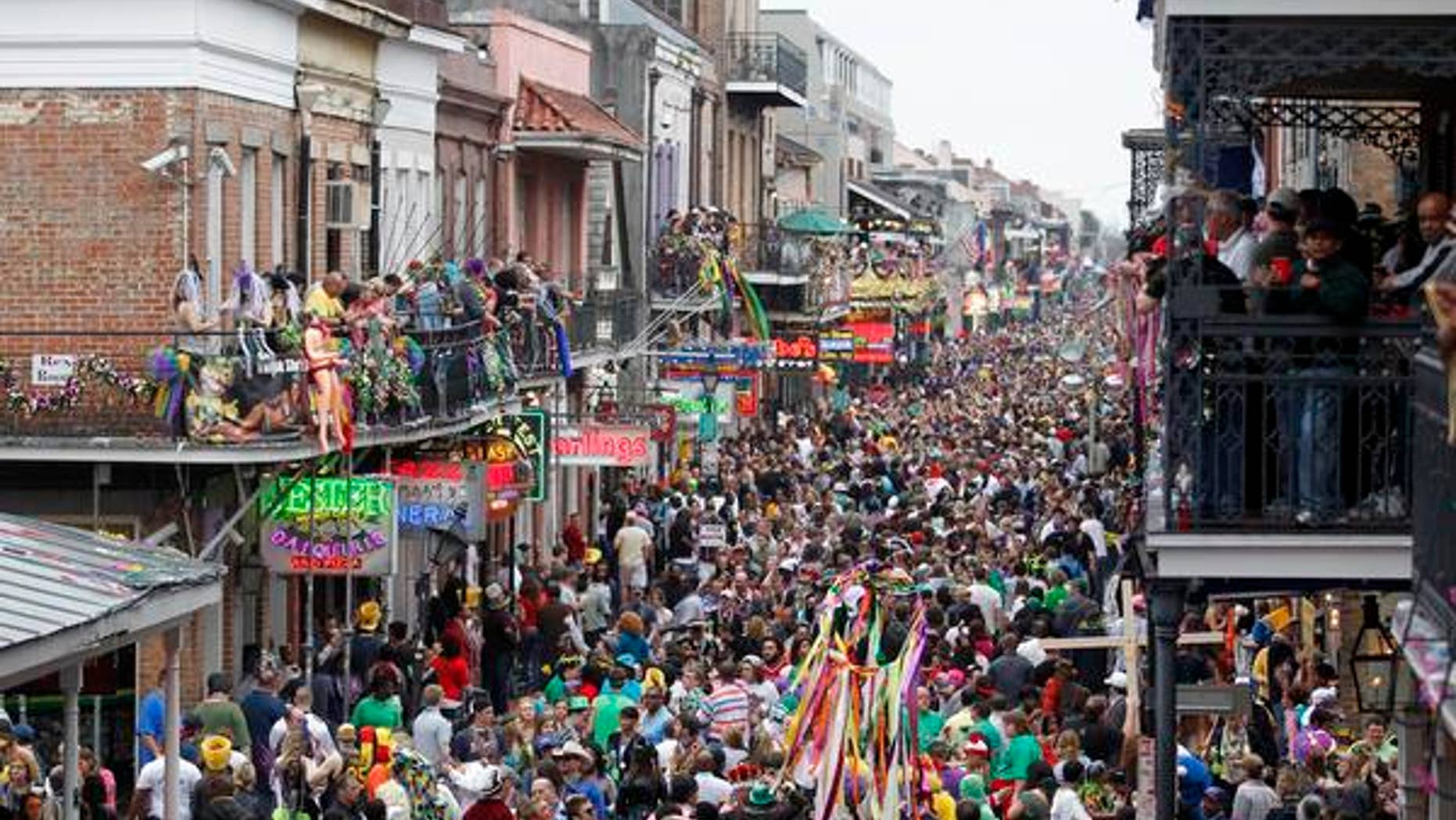 Mardi Gras crowds flood Bourbon Street.