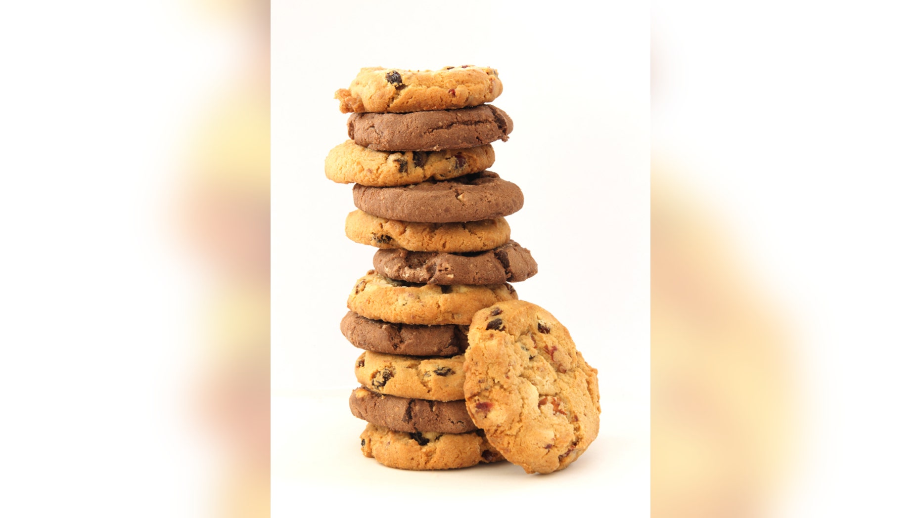 Stack of several chocolate and hazelnut cookies with chocolate chips and cranberies