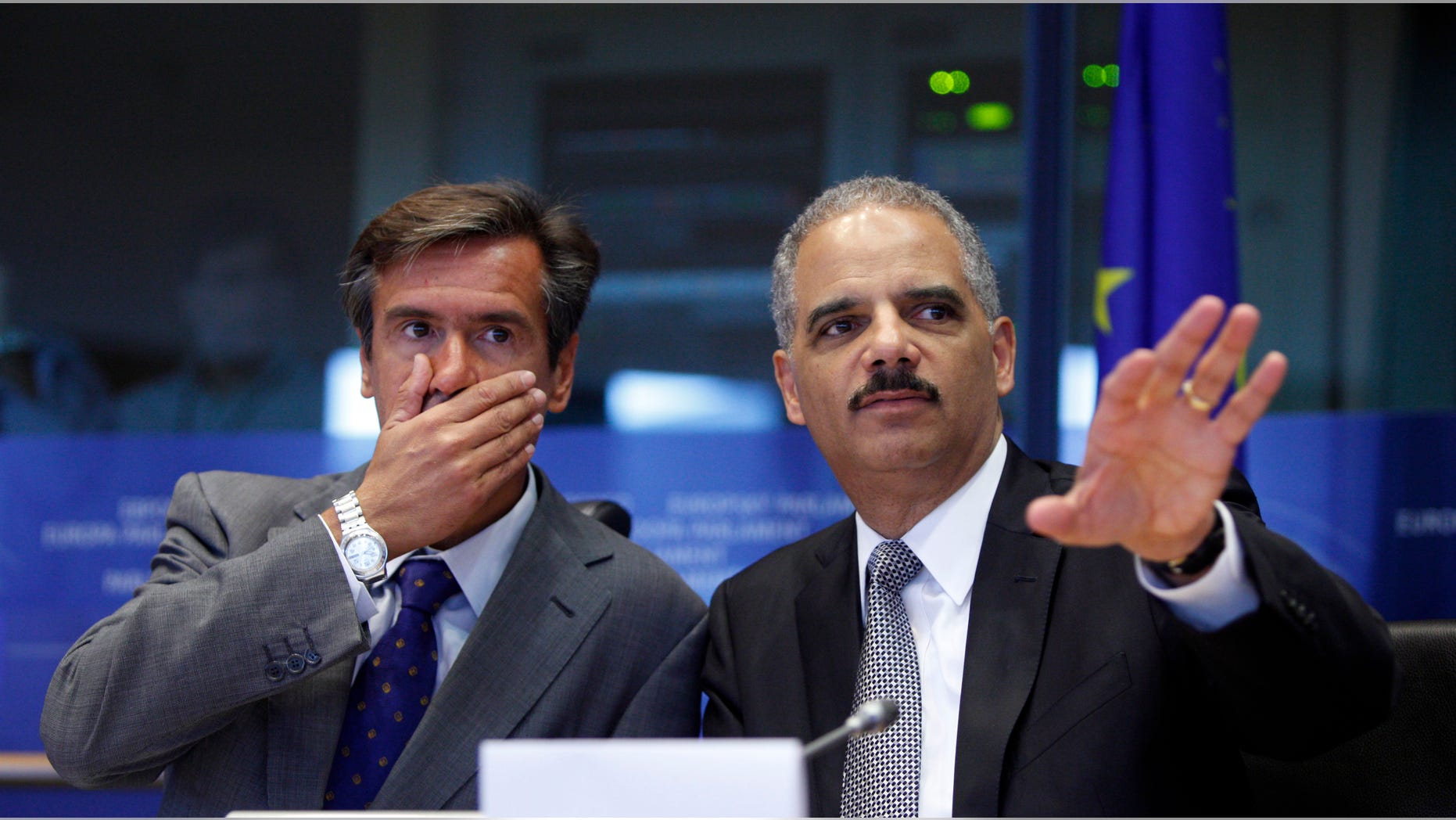 Spanish MEP Juan Fernandez Aguilar, left, looks on as United States Attorney General Eric Holder, right, speaks during a session at the European Parliament in Brussels on Tuesday, Sept. 20, 2011.