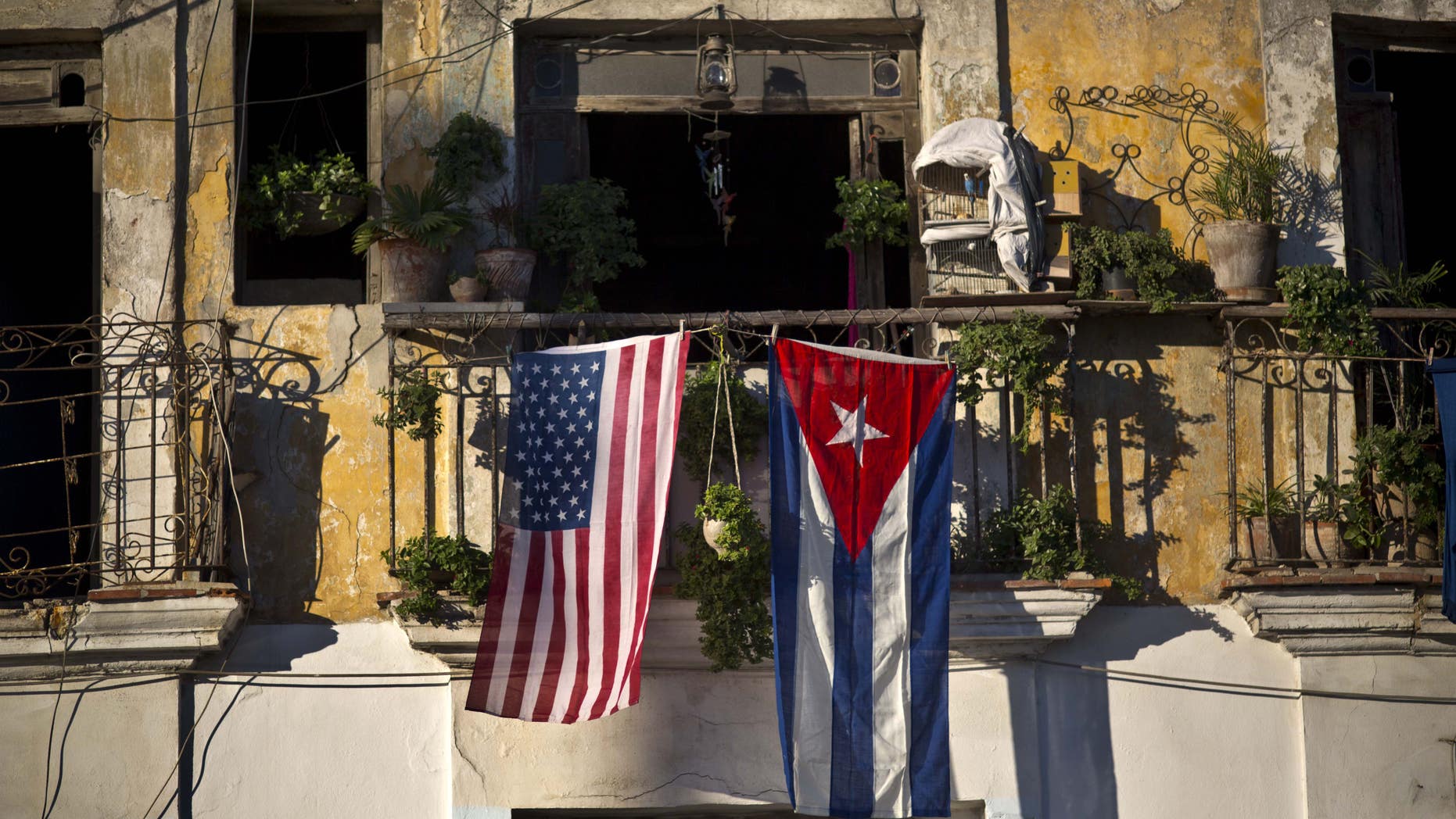 An American flag and a Cuban flag hang from a balcony in Old Havana.