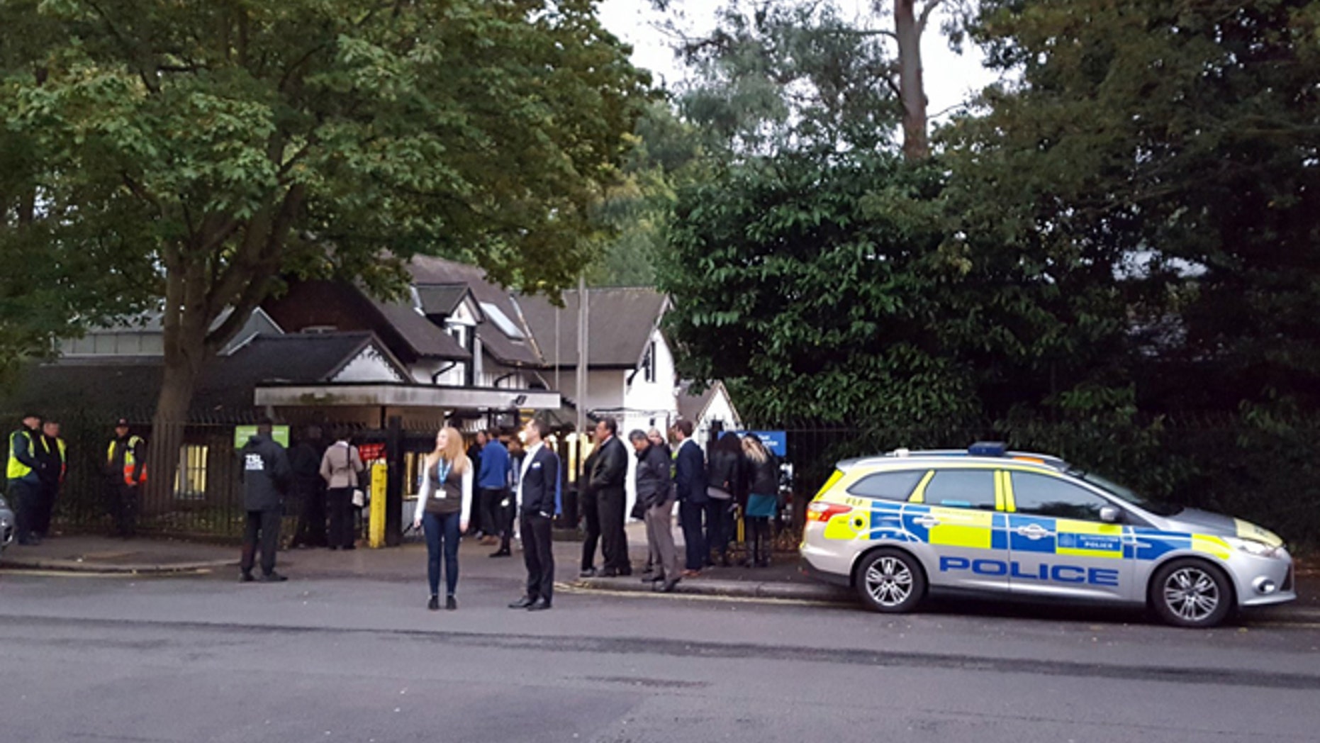 Police and evacuated visitors stand outside London Zoo after a gorilla escaped in London, Thursday, Oct. 13, 2016.