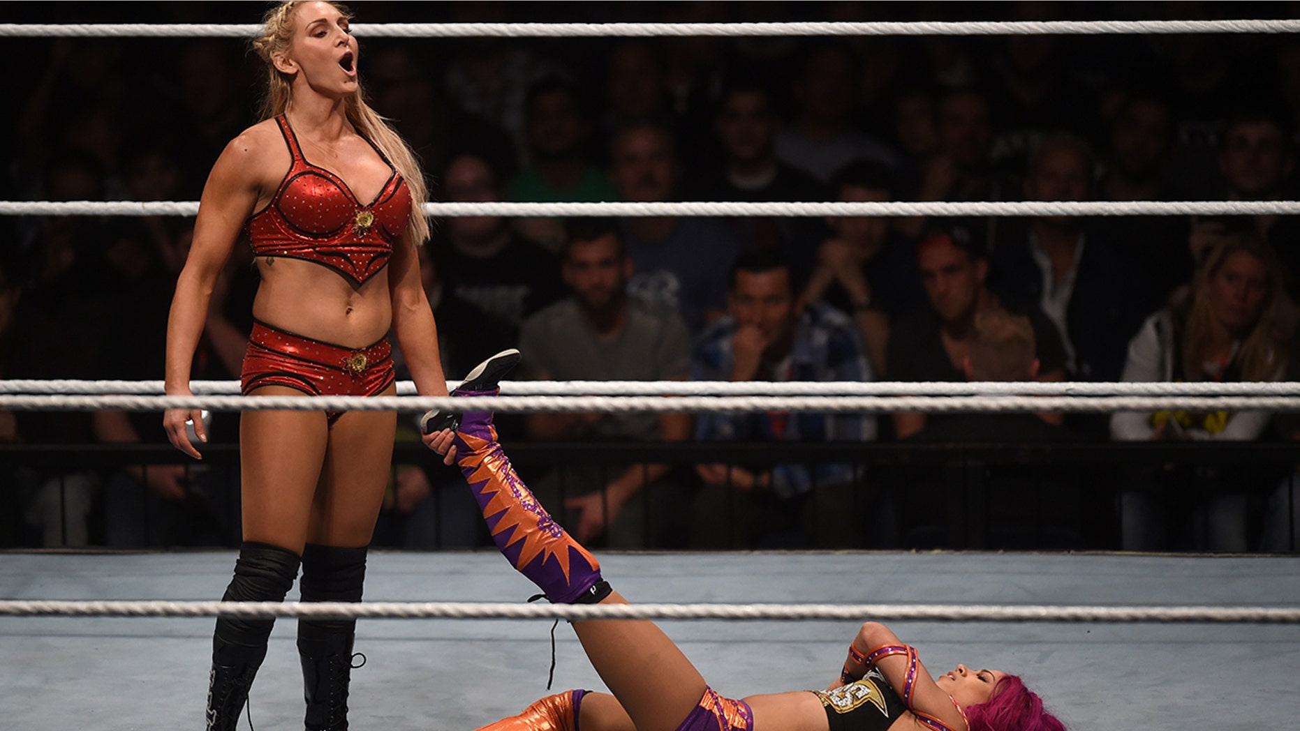 WWE wrestling stars Sasha Bank (R) and Charlotte Flair (L) fight during a WWE (World Wrestling Entertainment) women's fight at the Olympic hall in Munich, southern Germany, on November 3, 2016.