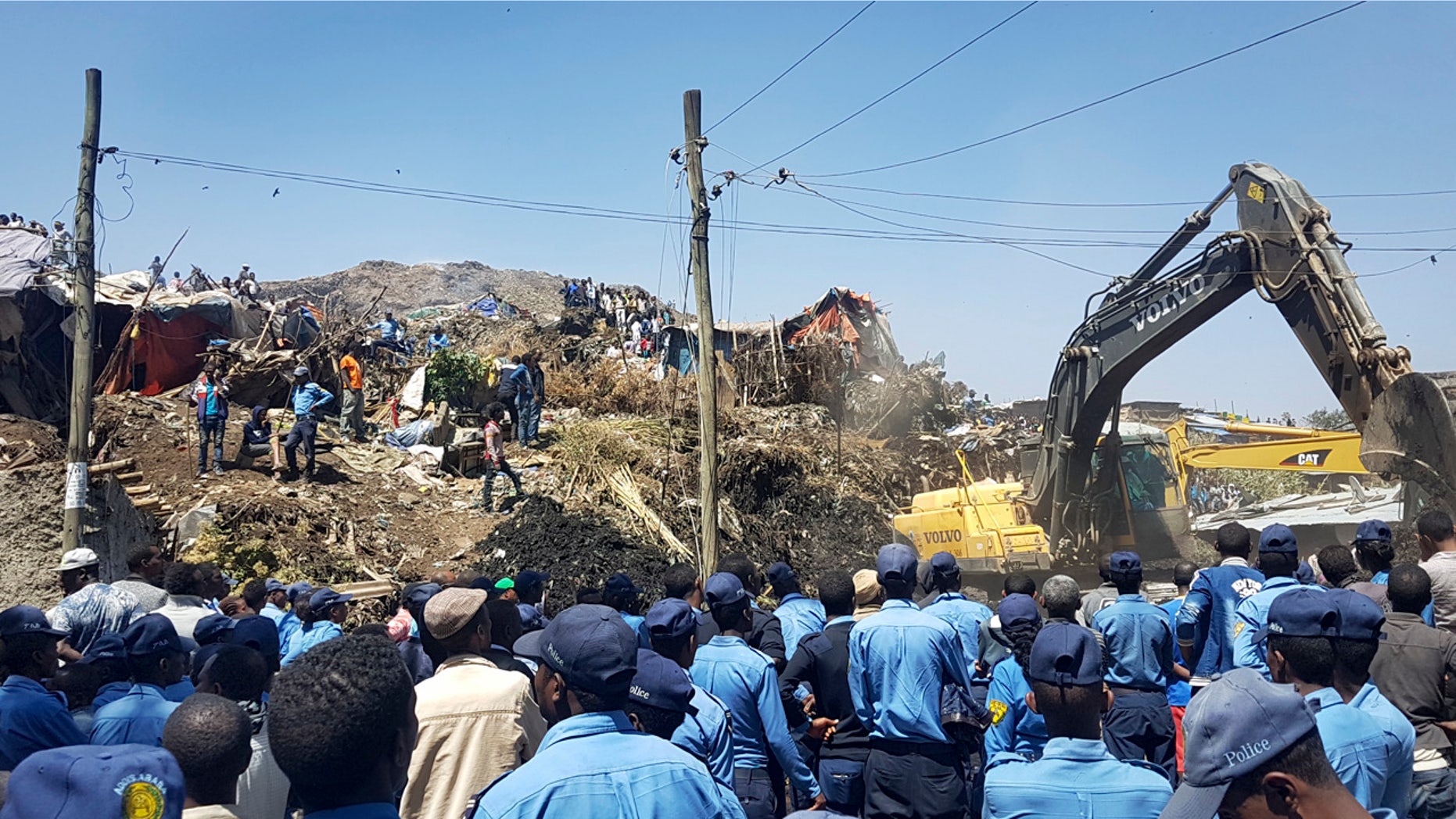 Police officers secure the perimeter at the scene of a garbage landslide, as excavators aid rescue efforts, on the outskirts of the capital Addis Ababa, Ethiopia Sunday, March 12, 2017.
