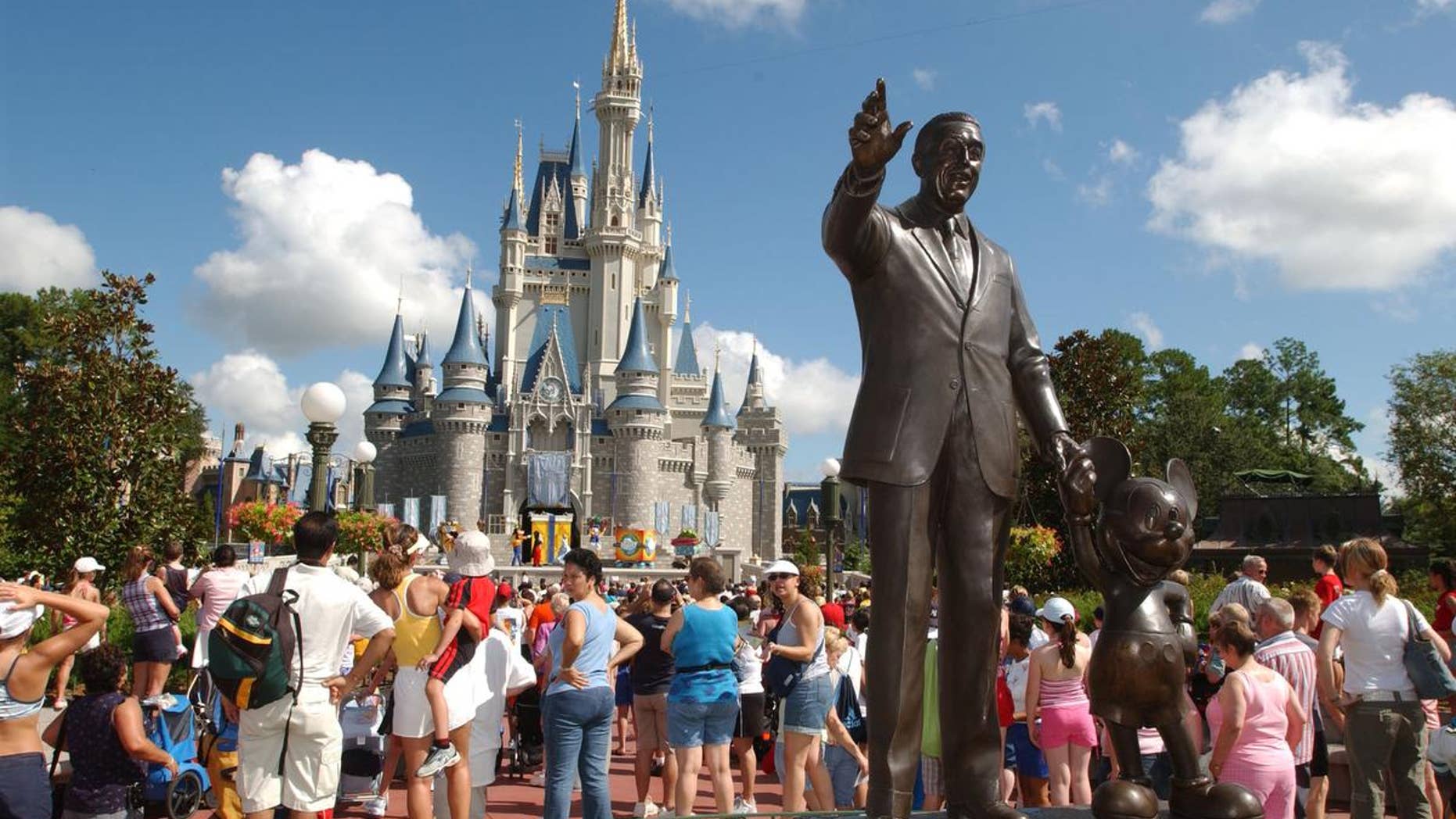 Tourists stop by Cinderella's Castle performance at Walt Disney World's Magic Kingdom in Lake Buena Vista, Fla.