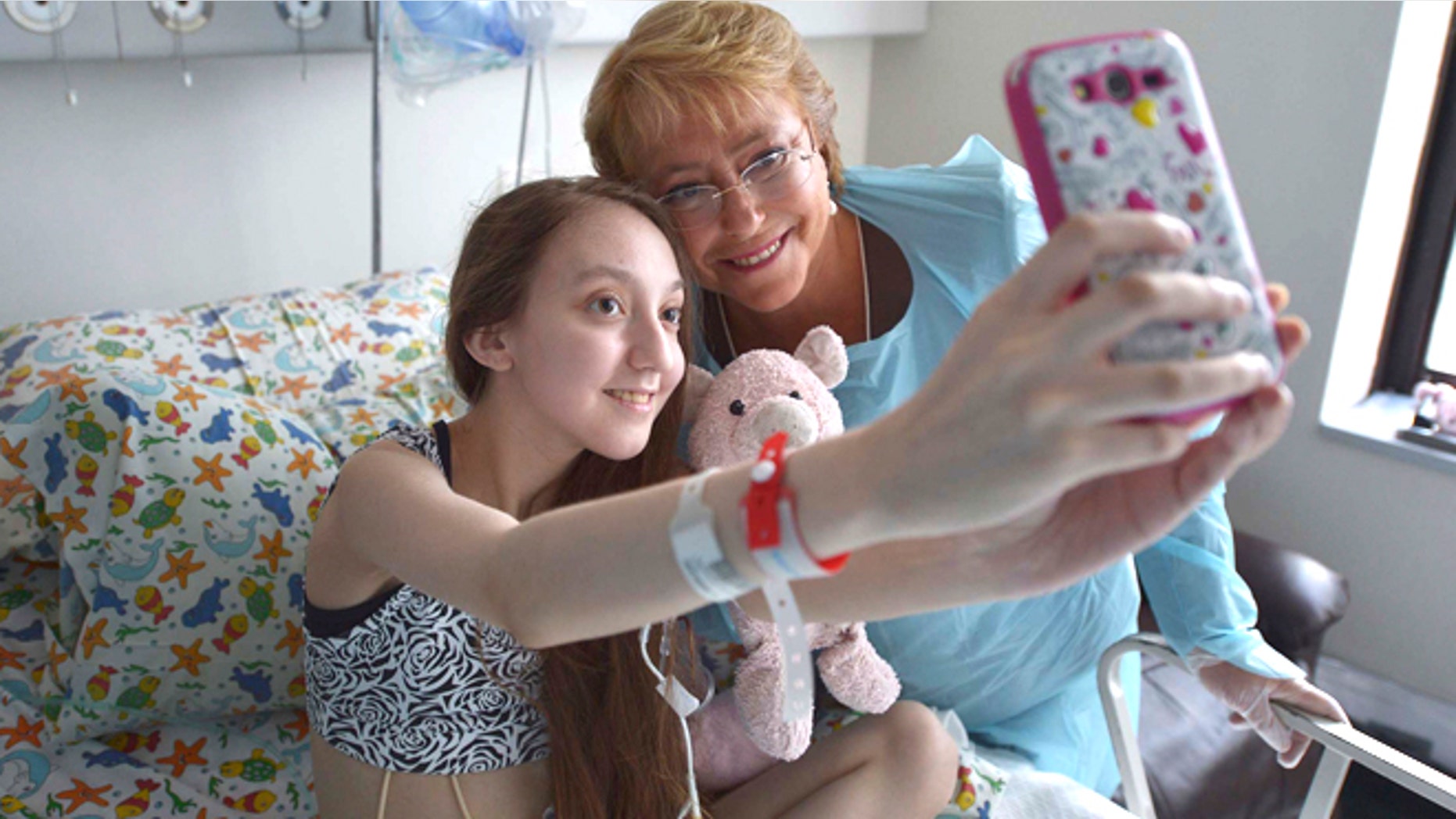 Feb. 28, 2015: In this photo released by Chile's Presidential Press Office, Valentina Maureira takes a photo of herself with President Michelle Bachelet, at the Catholic University hospital in Santiago, Chile.