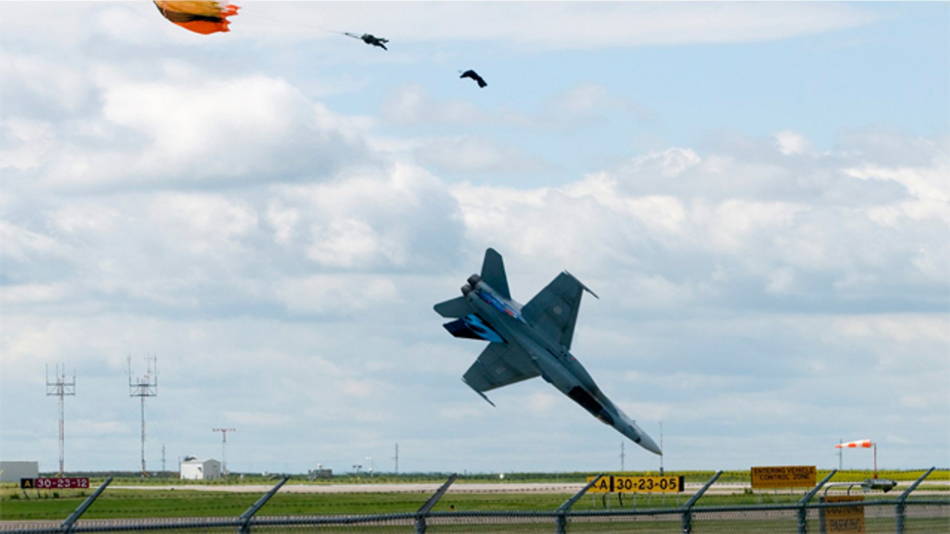 July 23: Pilot Capt. Brian Bews parachutes to safety as his a CF-18 fighter jet plummets to the ground during a practice flight at the Lethbridge County Airport for the weekend airshow in Lethbridge, Alberta, Canada.