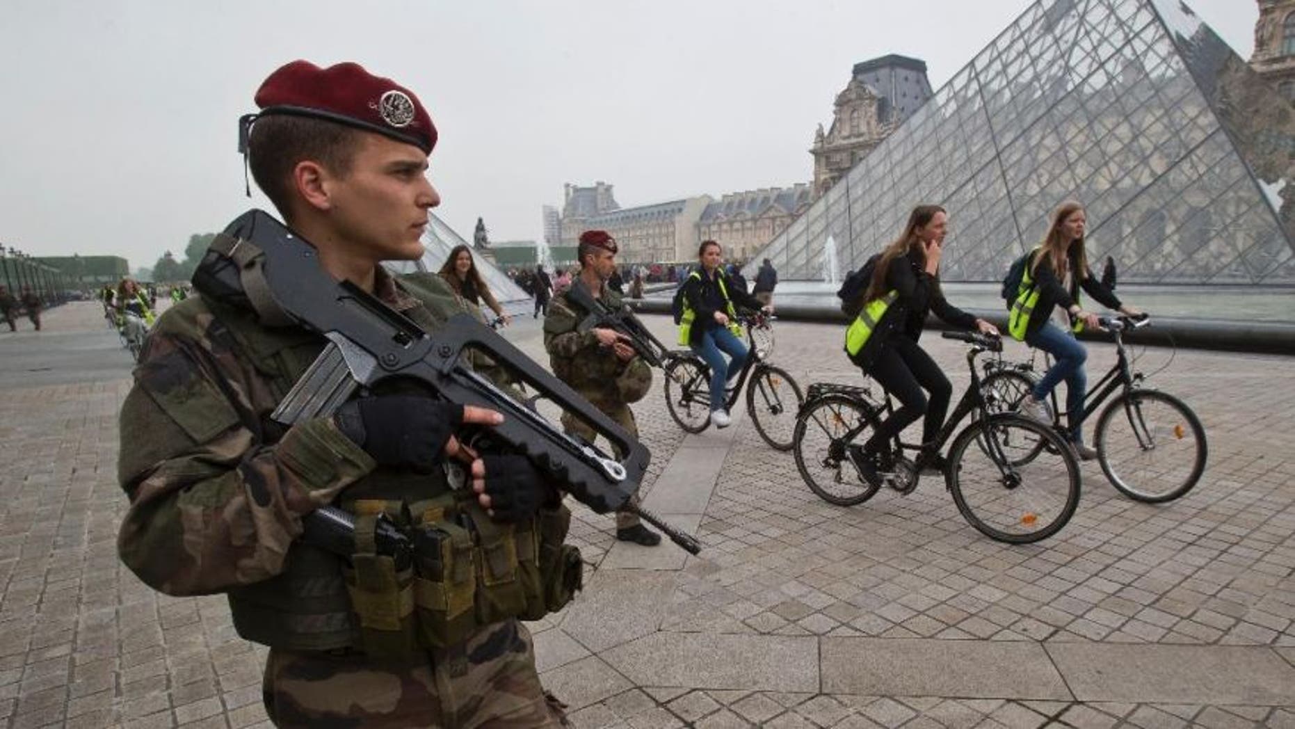 A French soldier staff sergeant Baudouin guards the iconic entrance to the Louvre museum in Paris, Friday, May 13, 2016.