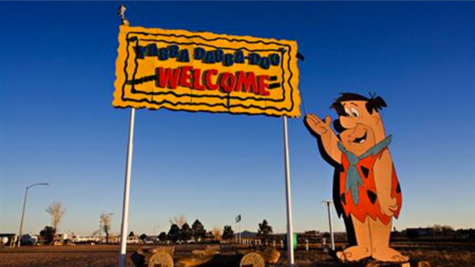 Fred Flintstone welcomes visitors to Bedrock City.