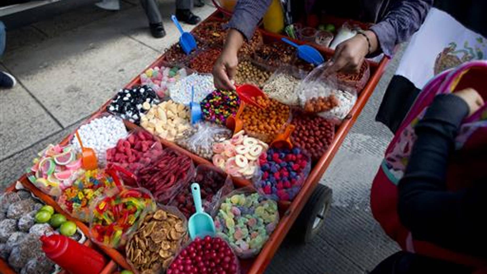 A street vendor sells sweet snacks in Mexico City, Tuesday, July 5, 2016.