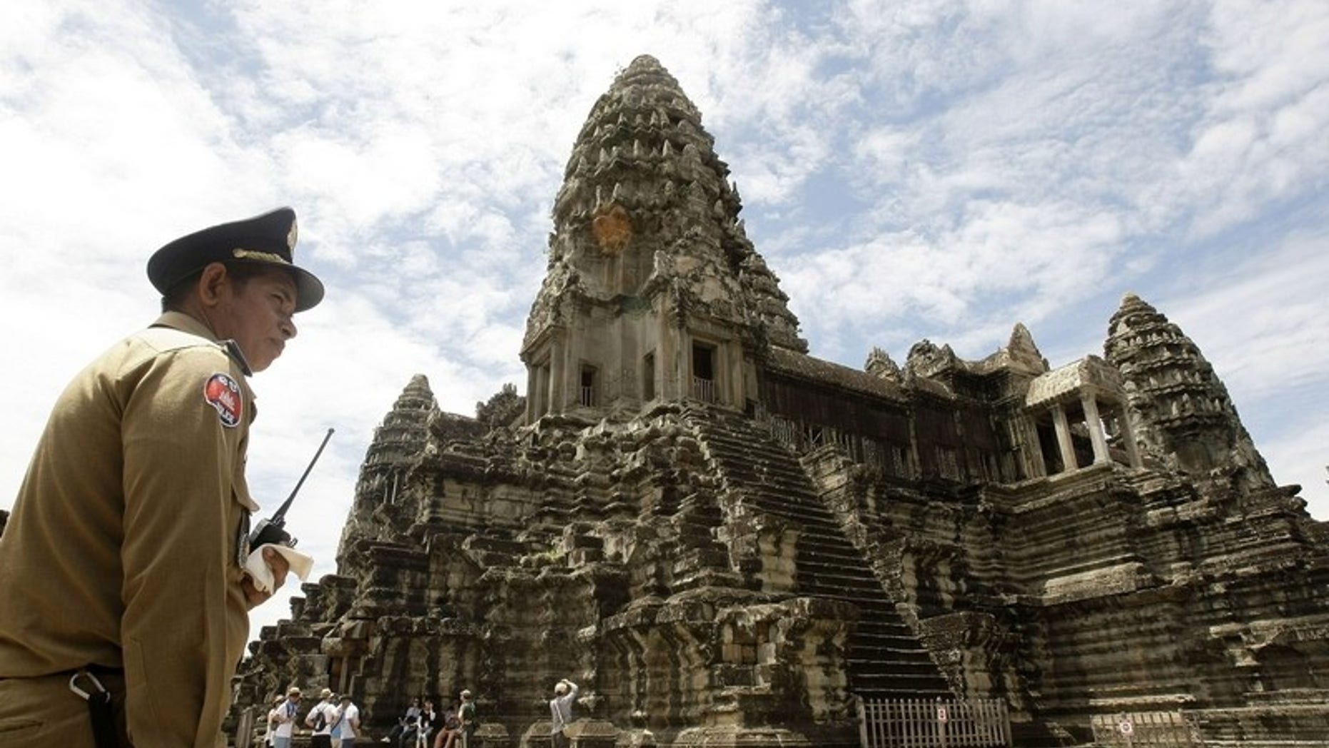 A Cambodian policeman stands guard outside the Angkor Wat temple complex.