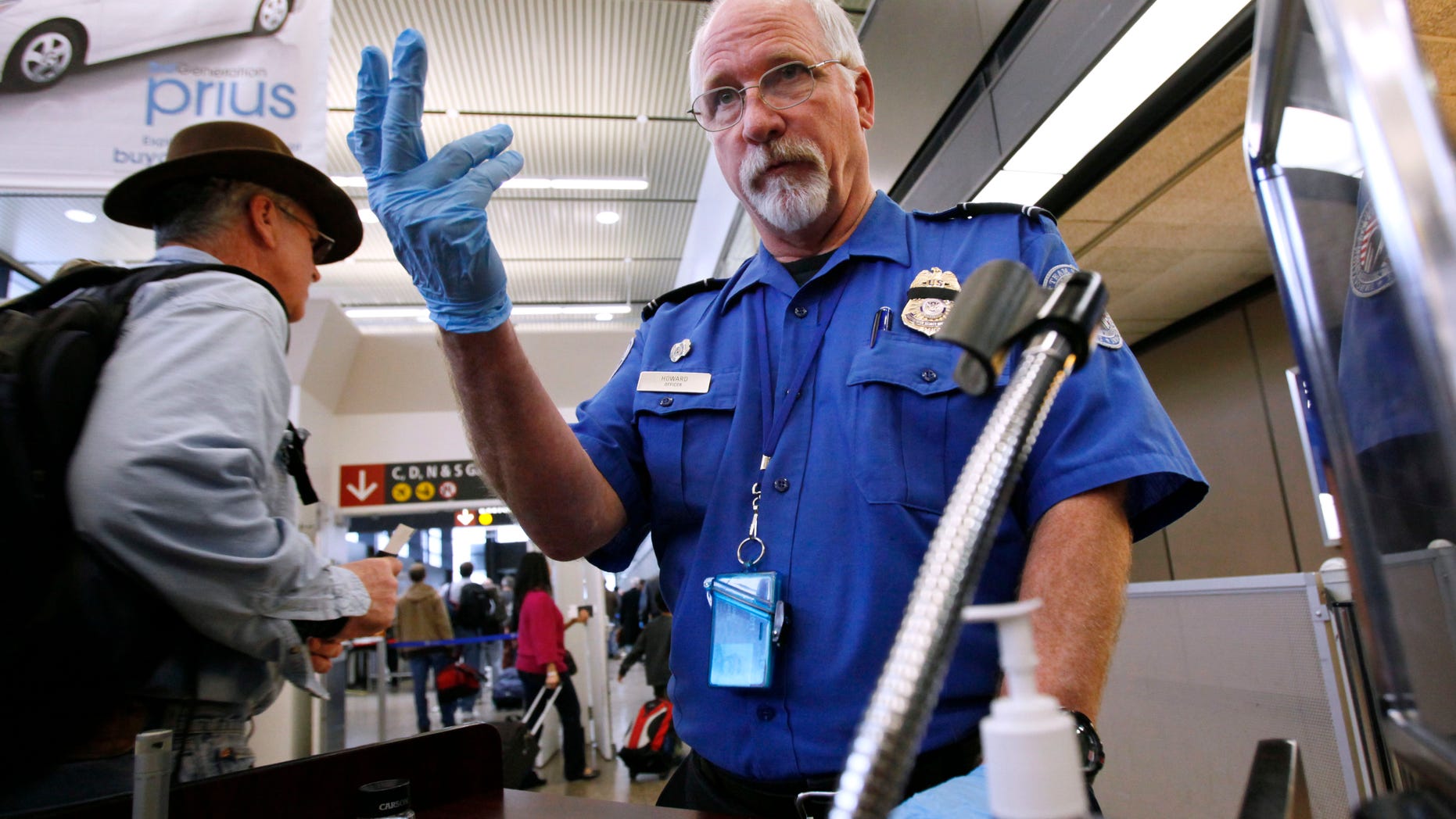 Next? A TSA agent beckons the next passenger at Seattle-Tacoma International Airport.