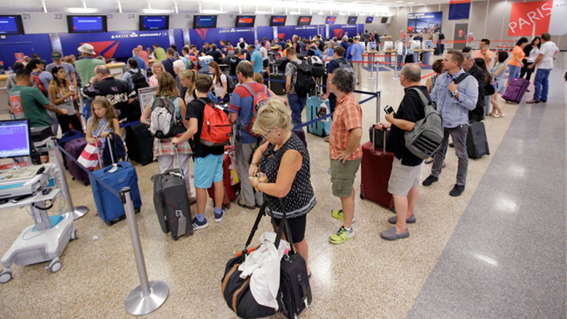 Delta Air Lines passengers stand in line after flights resumed Tuesday in Salt Lake City, Utah.