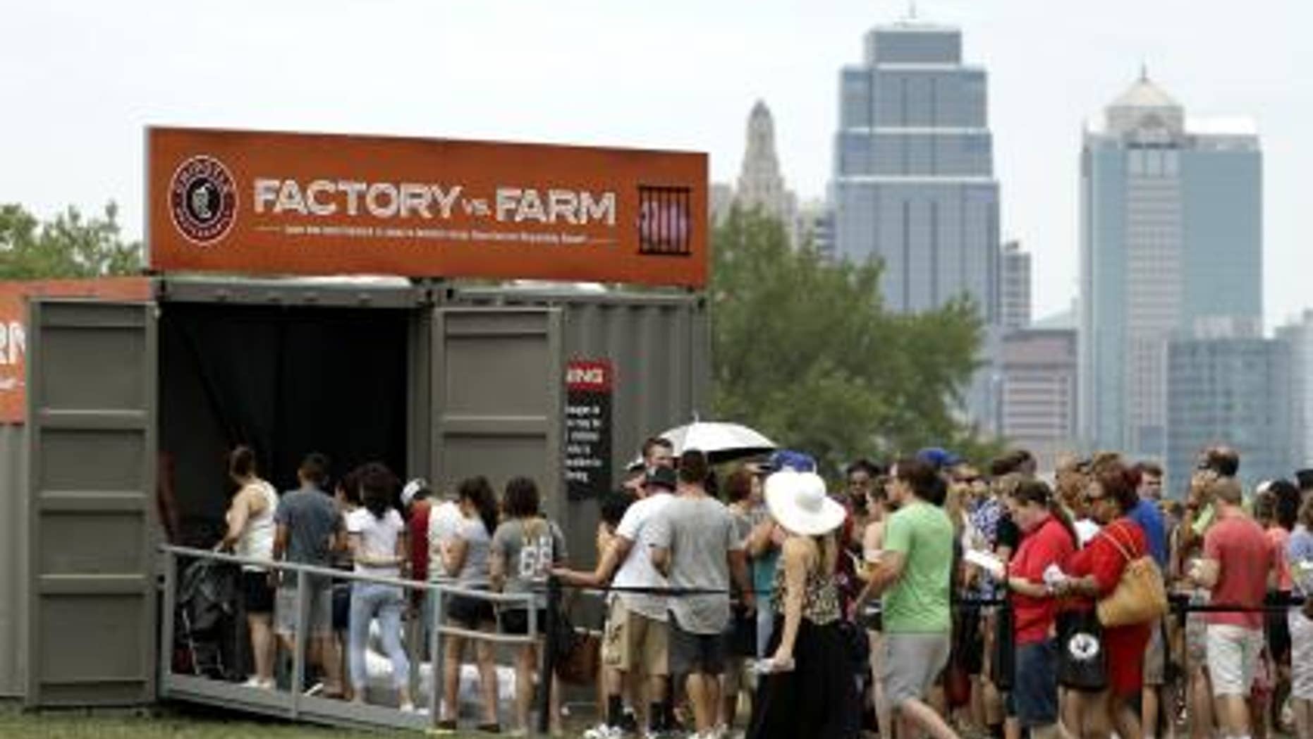 People line up to view a display contrasting processed versus fresh food production at Chipotle's Cultivate Festival in Kansas City, Mo. in July.