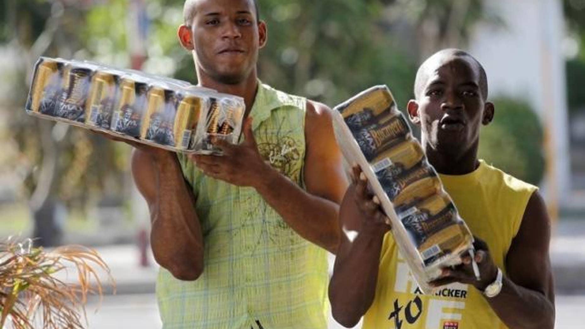 Men carry cartons of Bucanero beer in Havana, Cuba Oct. 20, 2009.