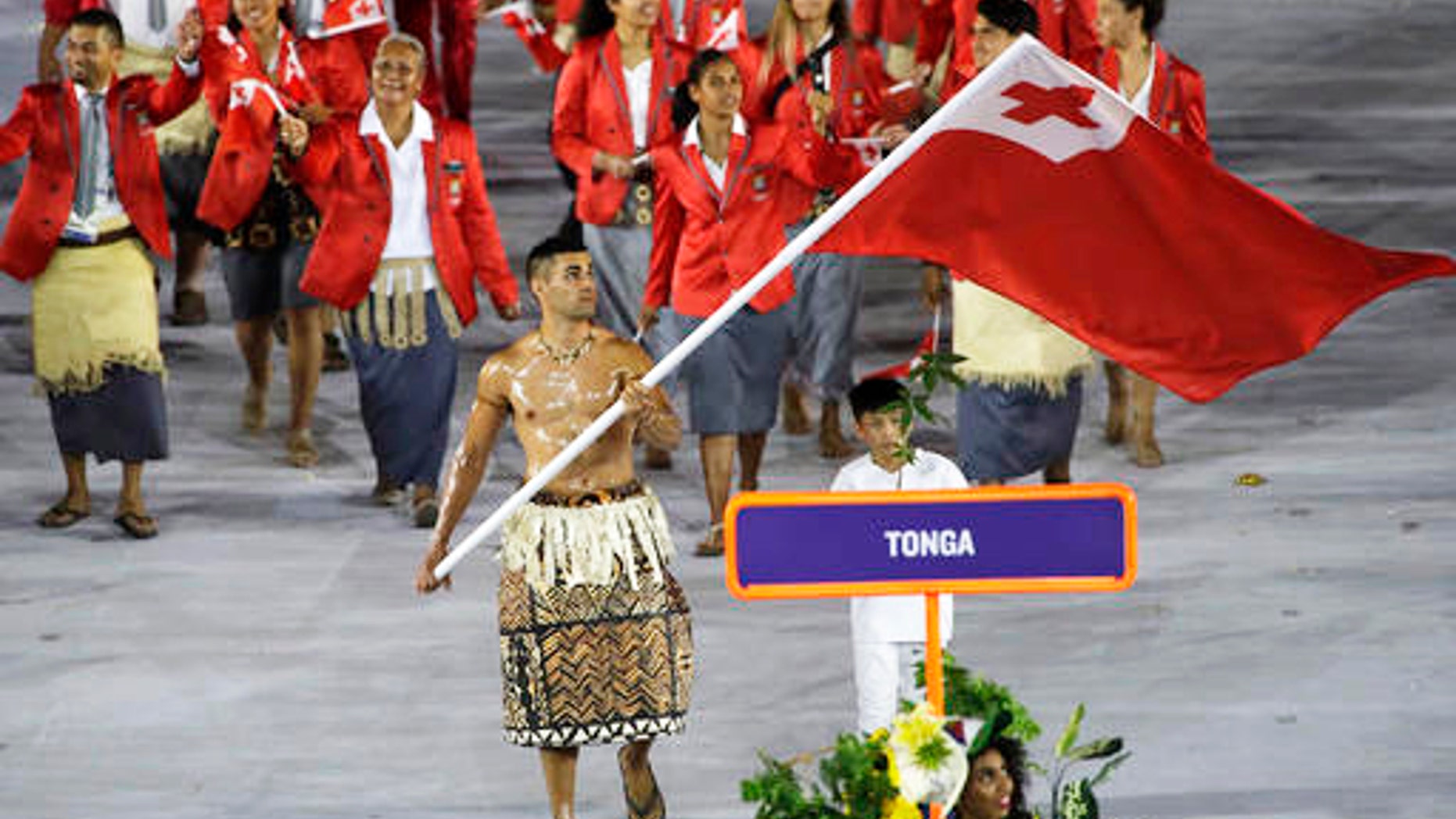 Pita Taufatofua carries the flag of Tonga during the opening ceremony for the 2016 Summer Olympics in Rio de Janeiro, Brazil, Friday, Aug. 5, 2016