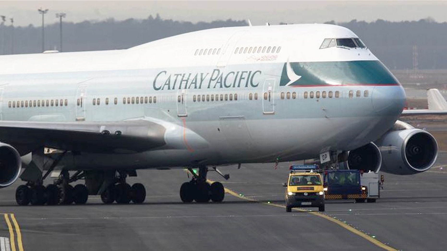 A Cathay Pacific Boeing B747-400 Aircraft is towed down the runway.