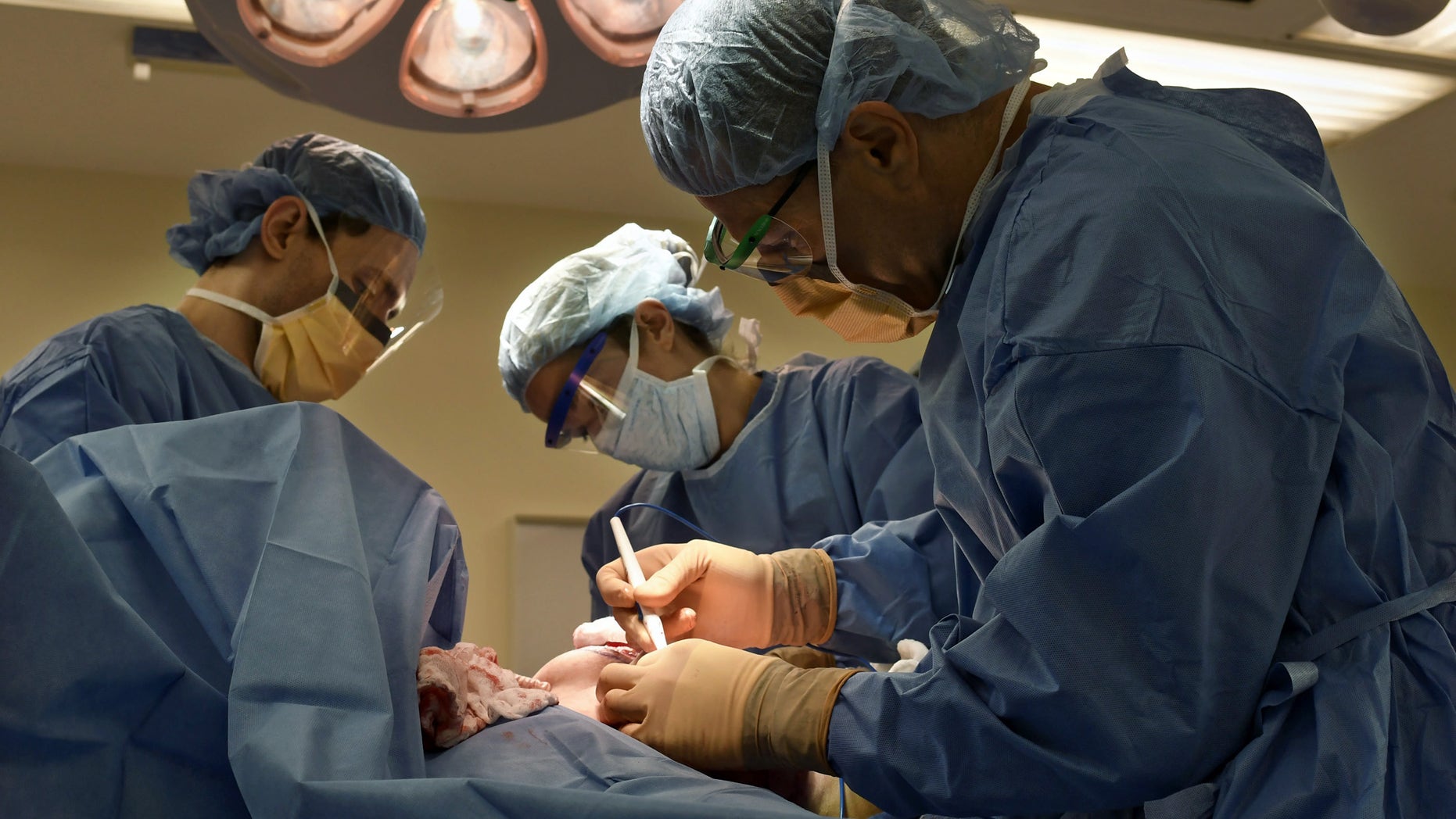 July 15, 2016: Surgeon Dr. Adam Tobias, far right, and Harvard Medical School residents Justin Cohen and Joani Christensen performing a bilateral mastectomy on EJ Silverberg at Beth Israel Deaconess Medical Center.