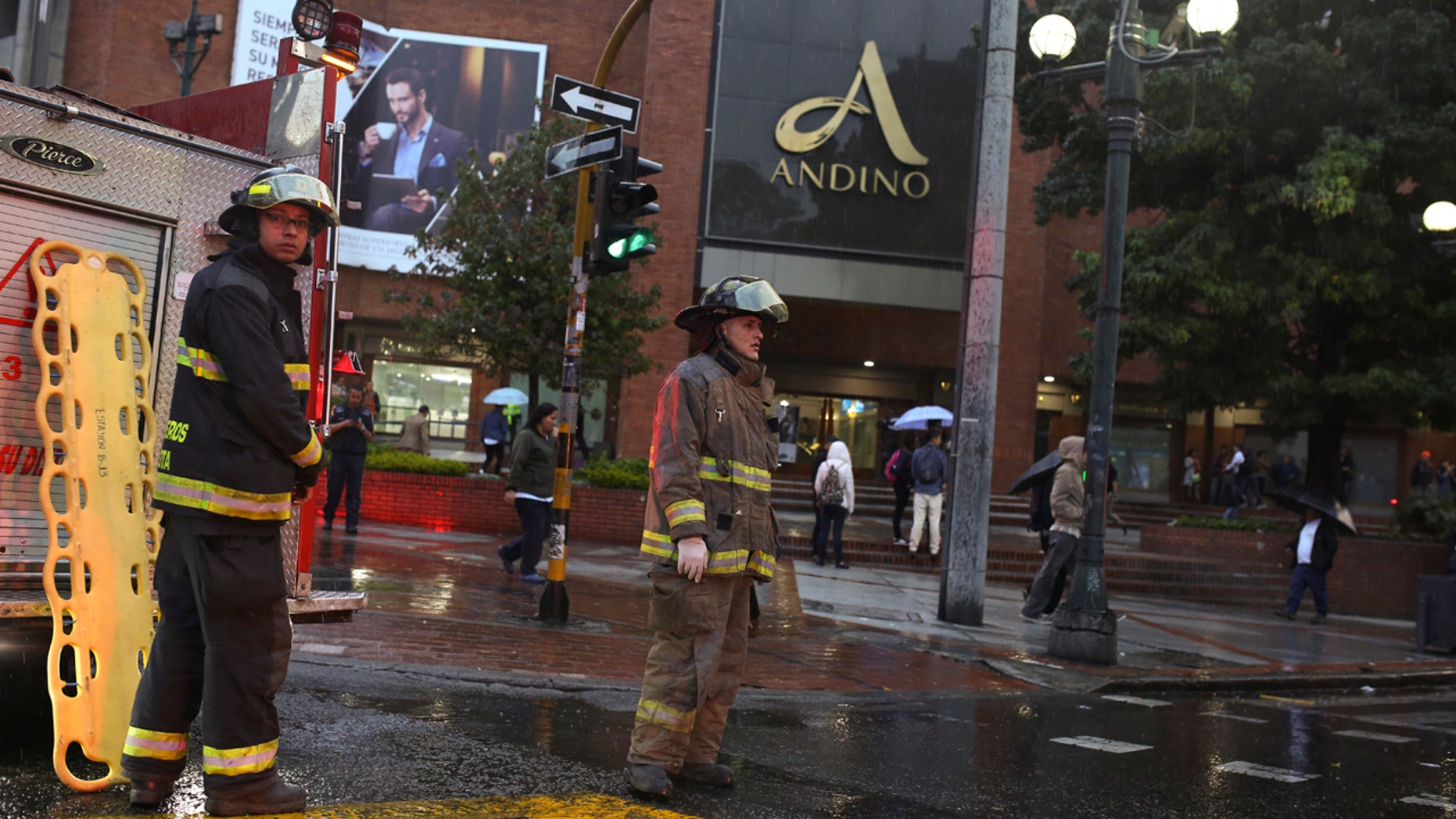 Firefighters stand outside the Centro Andino shopping center in Bogota, Colombia, Saturday, June 17, 2017.