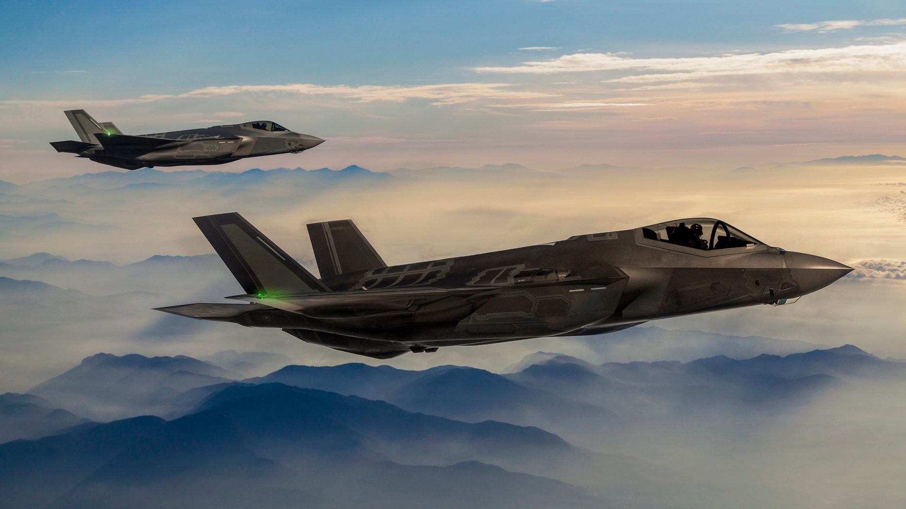 Fighter Jets flying over the foggy mountains at dusk (Credit: iStock)