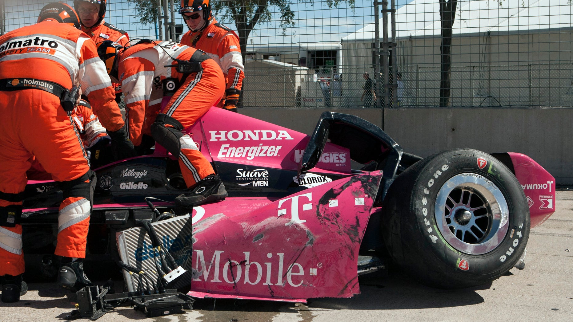 Safety team members work to remove Dario Franchitti, of Scotland, from his car after a crash during the second IndyCar Grand Prix of Houston auto race, Sunday, Oct. 6, 2013, in Houston. (AP Photo/Juan DeLeon)