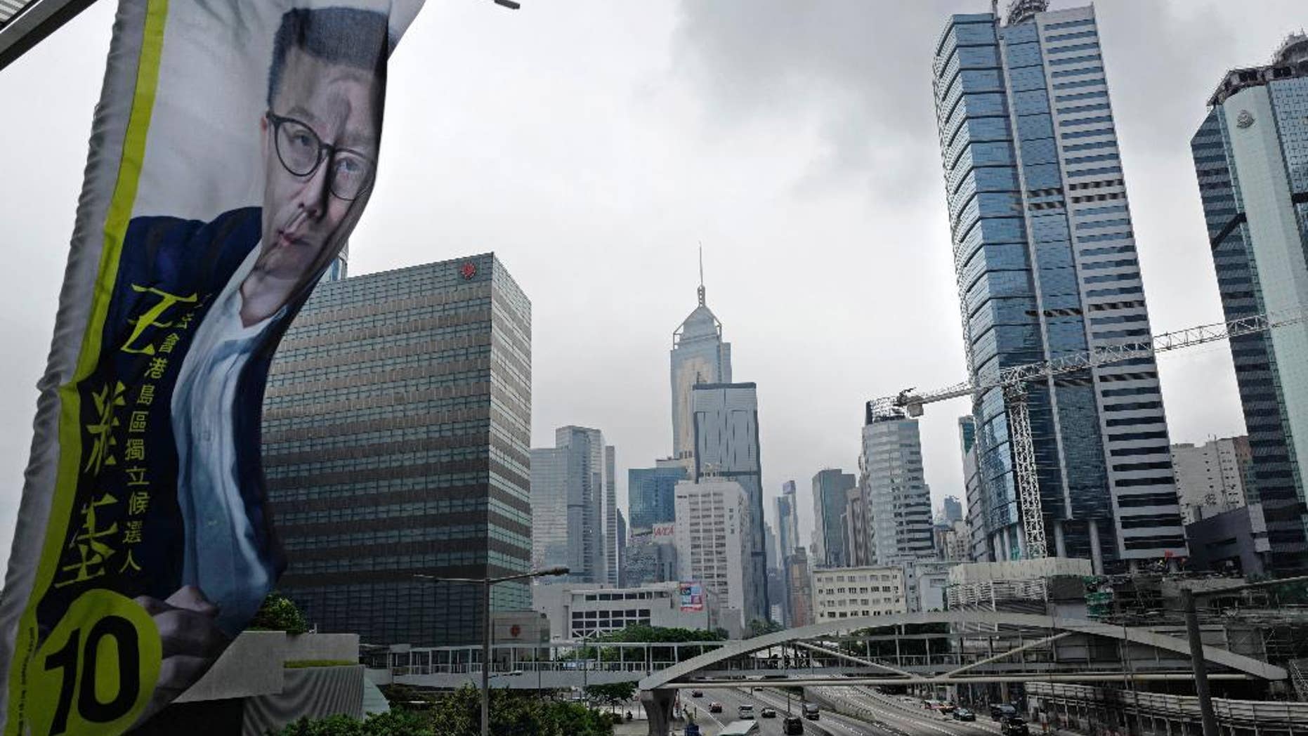 In this Aug. 29, 2016 photo, an election banner for Hong Kong election candidate Ricky Wong, a tycoon seen as a moderate, flutters over a busy road in Hong Kong. Hong Kongers head to the polls Sunday, Sept. 4, 2016 to choose candidates for the semiautonomous city’s legislature, in the first major election since 2014’s pro-democracy street protests. That movement drew world attention to the former British colony’s struggle over stunted democratic development under Chinese rule and paved the way for a burgeoning independence movement that’s complicating the upcoming vote. (AP Photo/Vincent Yu)