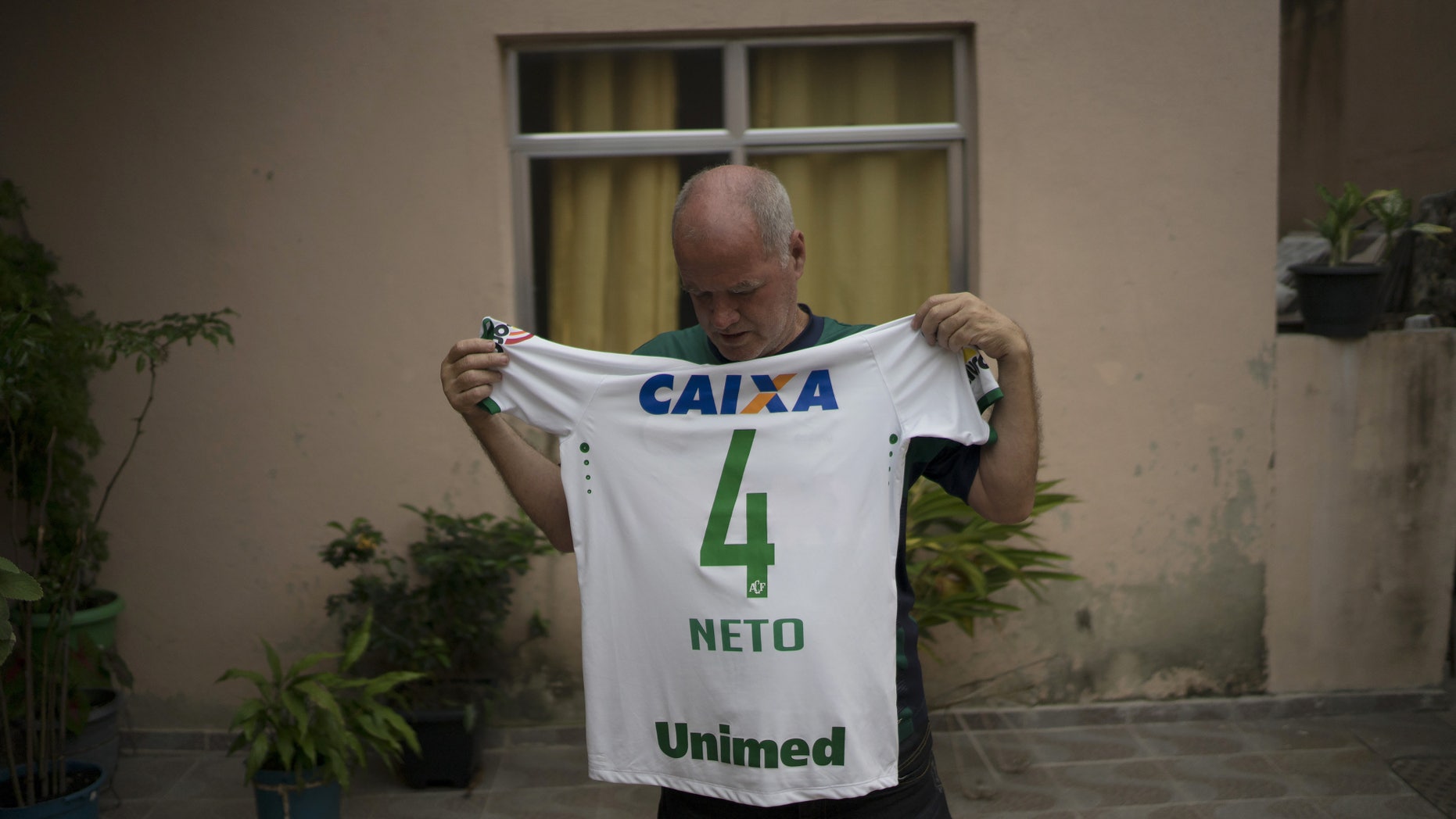 Helam Marinho Zampier Sr. shows the soccer jersey of his son Neto on Thursday, Dec. 1, 2016.