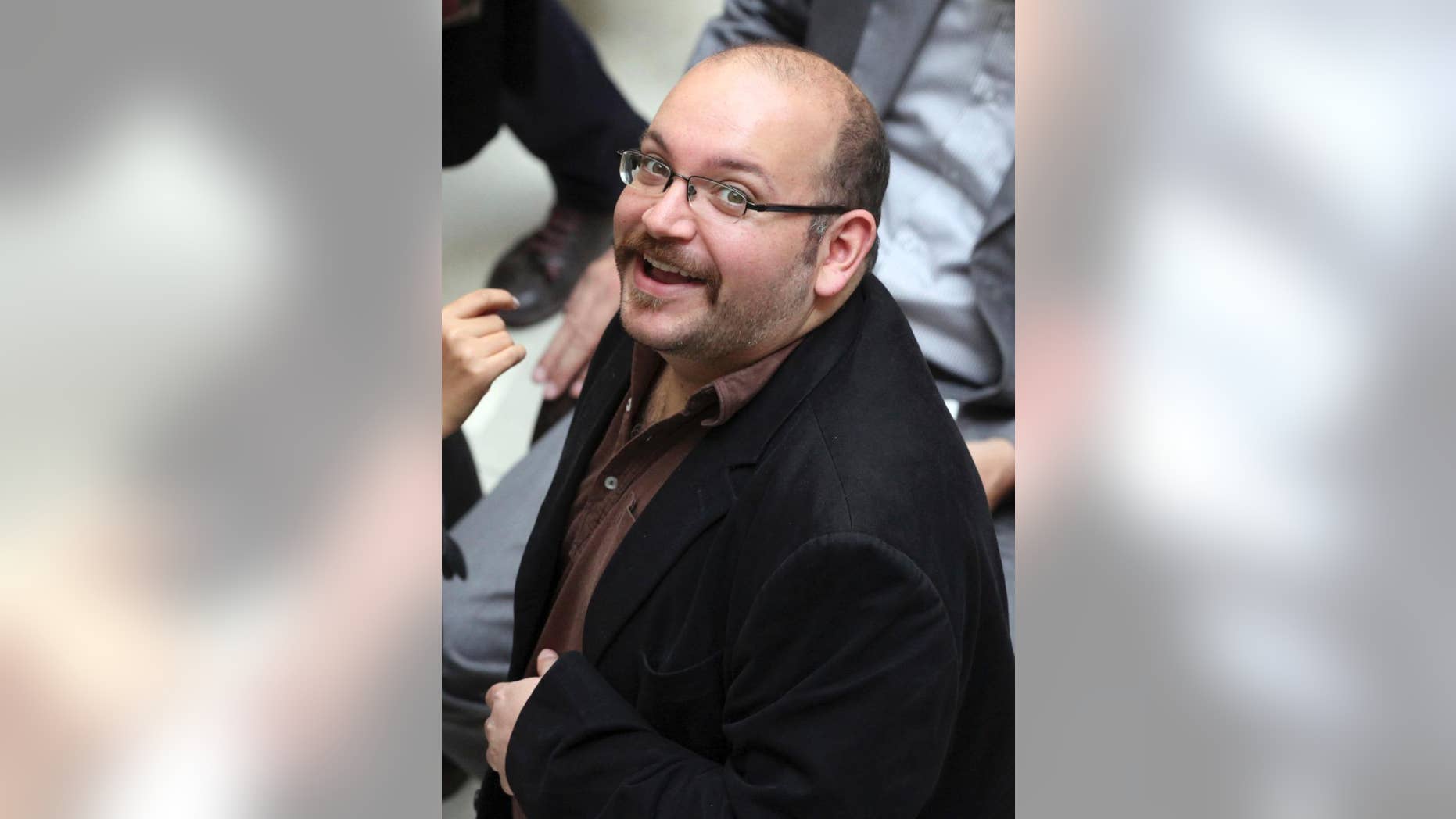 FILE - In this photo April 11, 2013 file photo, Jason Rezaian, an Iranian-American correspondent for the Washington Post smiles as he attends a presidential campaign of President Hassan Rouhani in Tehran, Iran. The family of Rezaian jailed without charge in Iran is urging authorities in Tehran to release him, calling his incarceration a “farce” 100 days after he was detained. (AP Photo/Vahid Salemi, File)