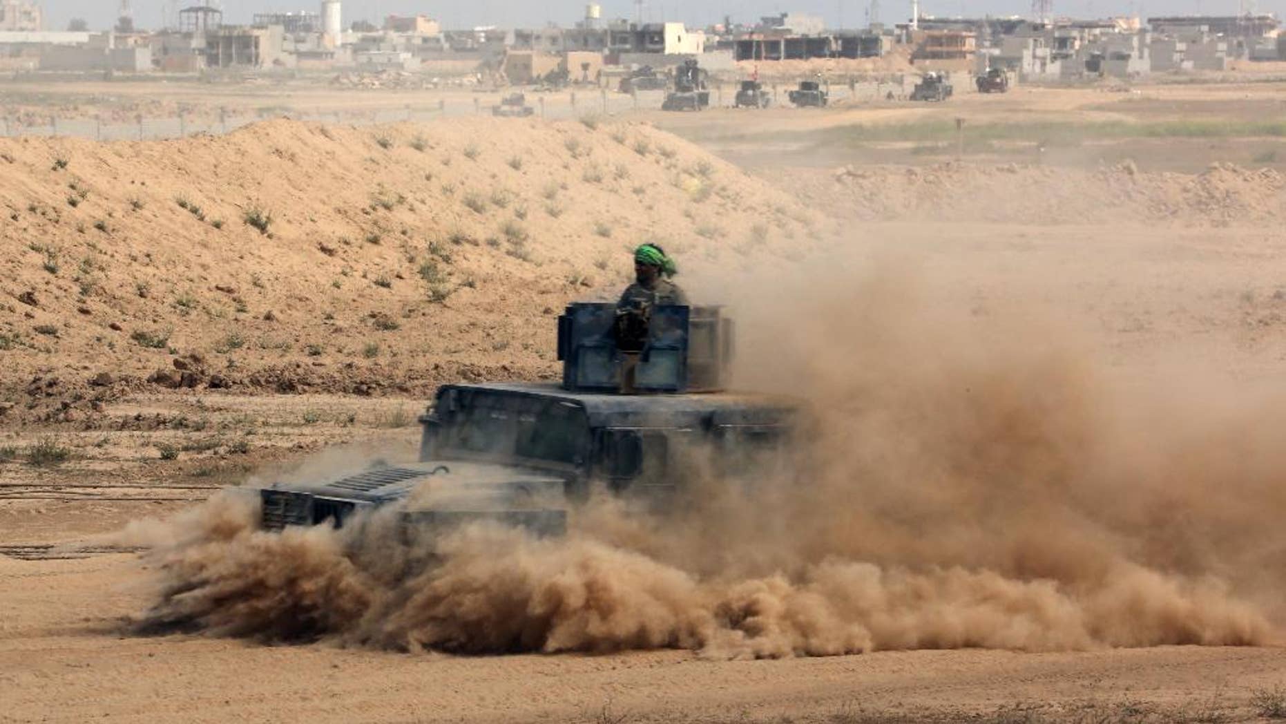 Iraqi security forces prepare to attack Islamic State extremist positions during clashes in Tikrit, 130 kilometers (80 miles) north of Baghdad, Iraq, Saturday, March 28, 2015. The Iraqi troops pressed their push in the city Saturday against IS militants holed up in the center of the city. (AP Photo/Khalid Mohammed)