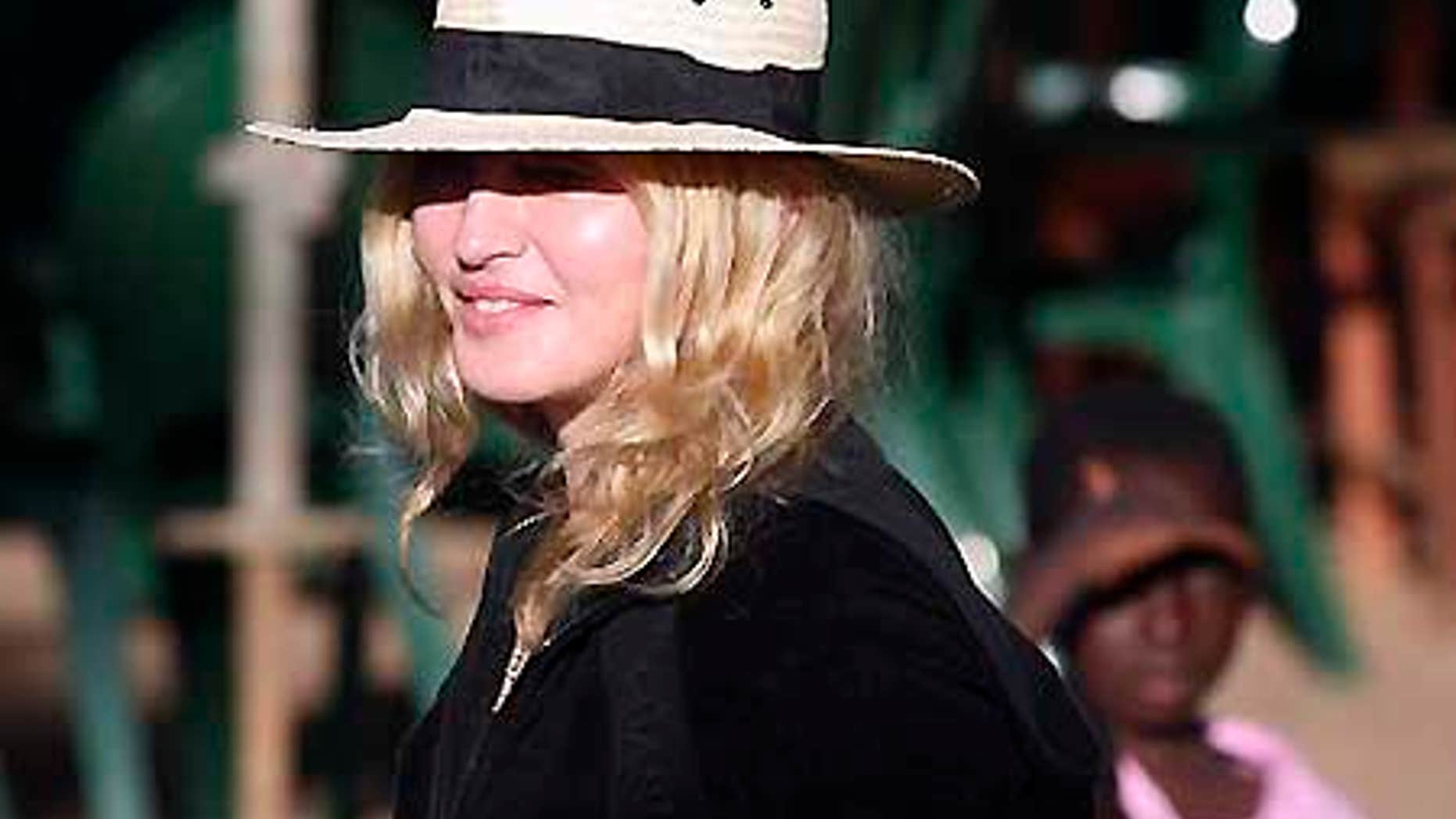 March 29, 2009: Pop star Madonna is watched by local children during a visit to Chinkhota village near Lilongwe, Malawi.