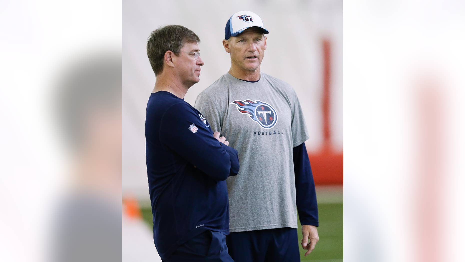 Tennessee Titans general manager Ruston Webster, left, and head coach Ken Whisenhunt talk during the NFL football minicamp on Monday, June 9, 2014, in Nashville, Tenn. (AP Photo/Mark Humphrey)