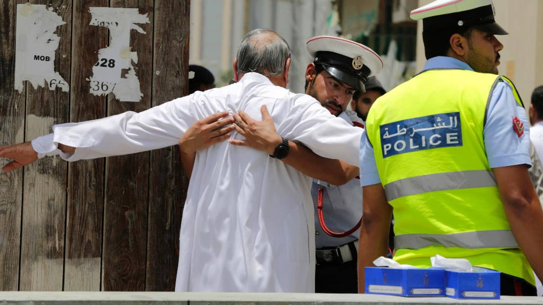FILE- In this Friday, June 5, 2015 file photo, Bahraini community police officers search worshipers outside a Shiite Muslim mosque ahead of mid-day prayers in Manama. Bahraini authorities say two policemen have been killed and many injured in a bomb attack south of the capital. The Interior Ministry said on its Twitter feed on Tuesday, July 28, 2015 that the officers were killed in a "terror blast" in the largely Shiite community of Sitra. (AP Photo/Hasan Jamali, File)