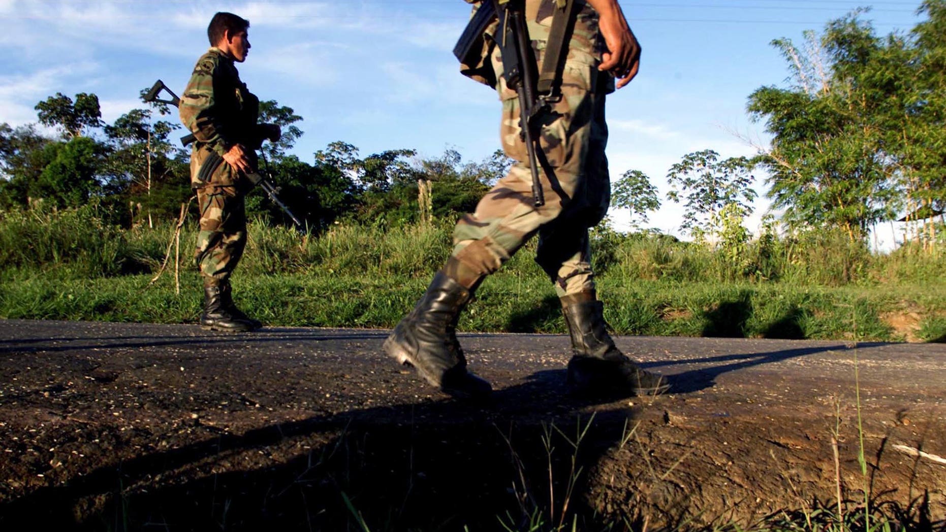 CAQUETA, COLOMBIA - JULY 31: Colombian soldiers patrol the highway that leads to San Vicente del Caguan from their base in Caqueta, Colombia on July 31, 2002. Despite a strong military presence in the former demilitarized zone, FARC guerrillas still maintain their control over the territories. (Photo by Carlos Villalon/Getty Images.)