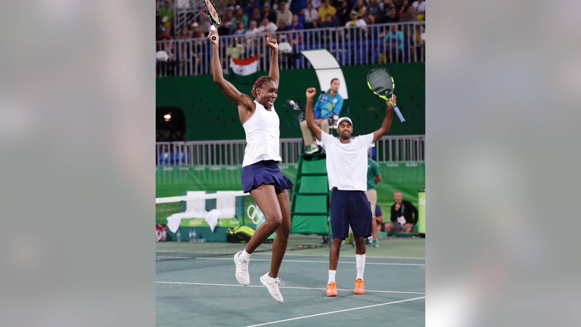 Venus Williams, left, and her partner Rajeev Ram, of the United States, celebrate after defeating India during their semi-final mixed doubles match at the 2016 Summer Olympics in Rio de Janeiro, Brazil, Saturday, Aug. 13, 2016. The United States advances to the gold medal game. (AP Photo/Charles Krupa)