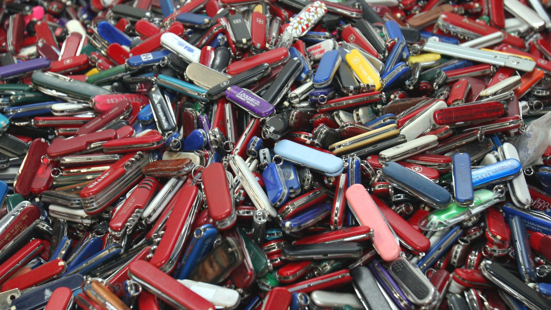 FILE - In this Sept. 26, 2006, file photo, knives of all sizes and types are piled in a box at the State of Georgia Surplus Property Division store in Tucker, Ga., and are just a few of the hundreds of items discarded at the security checkpoints of Hartsfield-Jackson Atlanta International Airport that will be for sale at the store. Federal officials say they’re delaying a policy that would allow passengers to carry small knives, bats, and other sports equipment onto airliners. The Transportation Security Administration said Monday, April 22, 2013, that the policy change has been delayed to accommodate feedback from an advisory committee made up of aviation industry, consumer, and law enforcement officials.(AP Photo/Gene Blythe, File)
