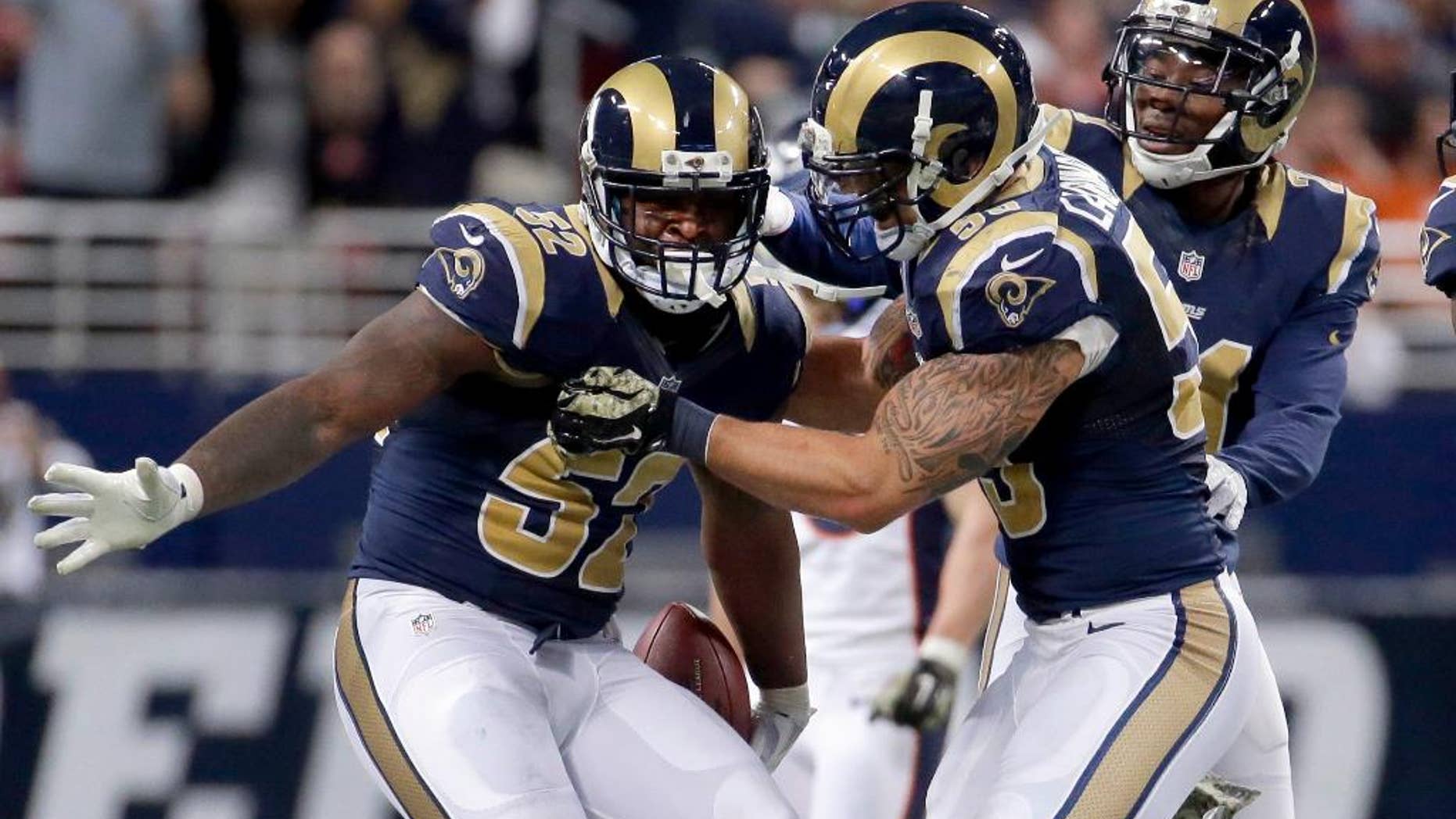 St. Louis Rams linebacker Alec Ogletree, left, is congratulated by teammates James Laurinaitis, center, and Janoris Jenkins after intercepting a pass during the fourth quarter of an NFL football game against the Denver Broncos, Sunday, Nov. 16, 2014, in St. Louis. (AP Photo/Charlie Riedel)