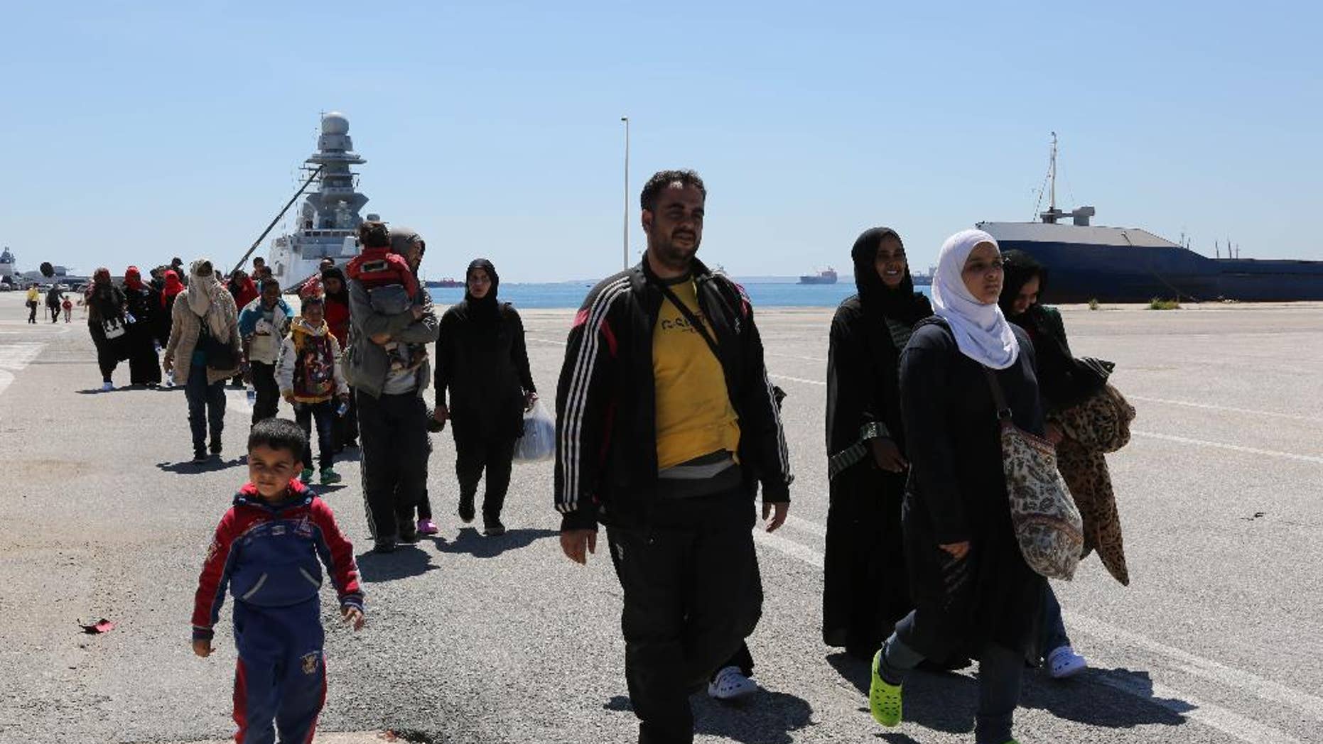 Rescued migrants walk after disembarking from an Italian Navy vessel in the harbor of Augusta, Sicily, Southern Italy, Wednesday, April 22, 2015. Italy pressed the European Union on Wednesday to devise concrete, robust steps to stop the deadly tide of migrants on smugglers' boats in the Mediterranean, including setting up refugee camps in countries bordering Libya. Italian Defense Minister Roberta Pinotti also said human traffickers must be targeted with military intervention. (AP Photo/Francesco Malavolta)