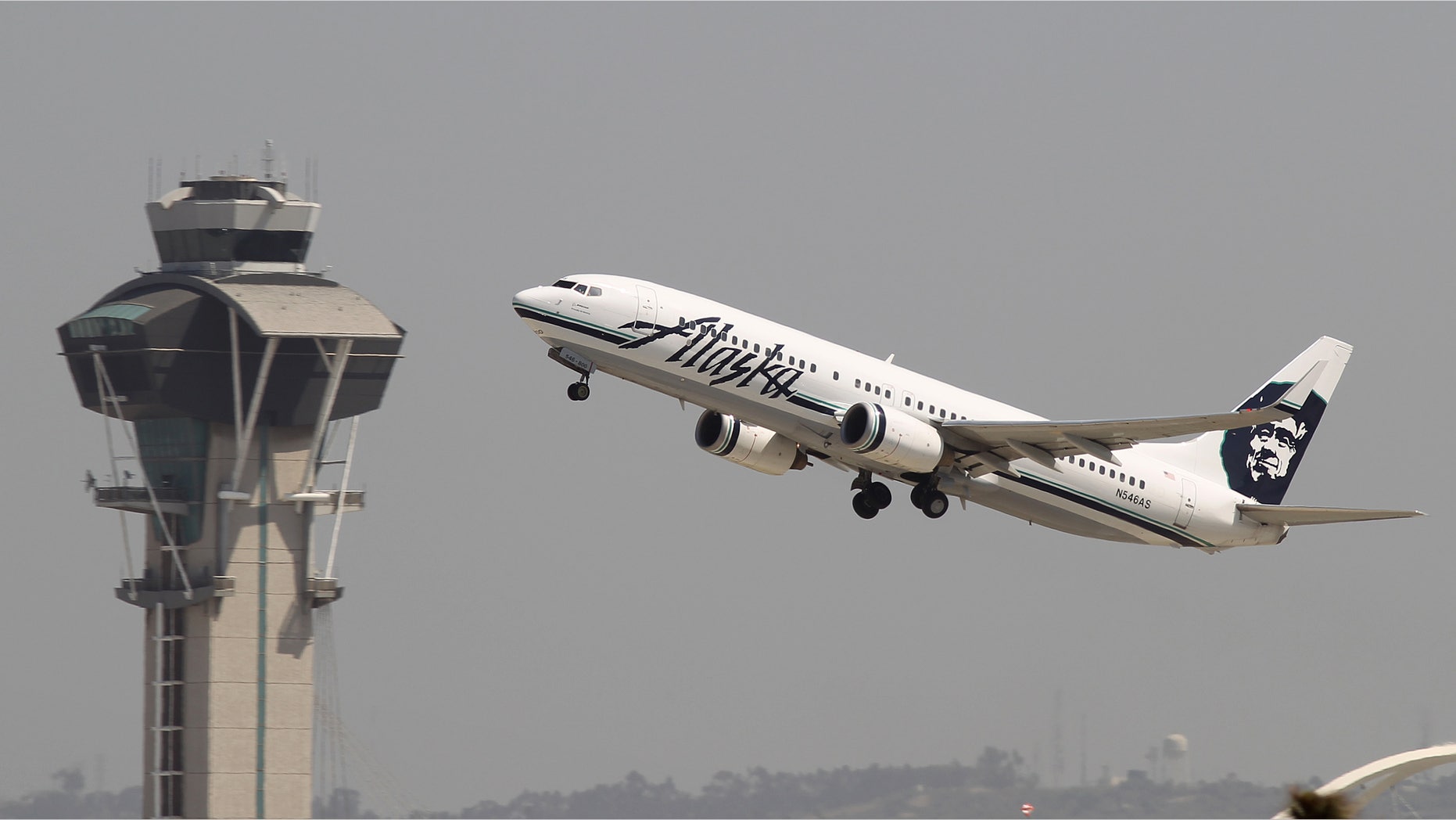 LOS ANGELES, CA - APRIL 22: An Alaska Airlines jet passes the air traffic control tower at Los Angles International Airport (LAX) during take-off on April 22, 2013 in Los Angeles, California. Delays have been reported throughout the nation because of the furloughing of air traffic controllers under sequestration. The average delay overnight in the Southern California Terminal Radius Approach Control (TRACON) was was three hours. (Photo by David McNew/Getty Images)