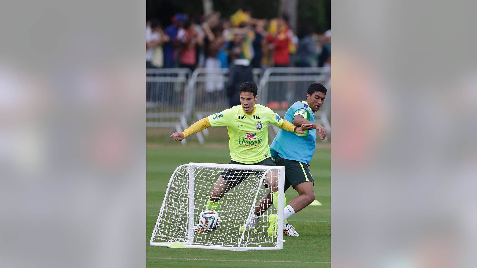 Brazil's Hernanes, left, and Paulinho, practice during a training session at the Granja Comary training center in Teresopolis, Brazil, Monday, June 30, 2014. Brazil will face Colombia on July 4 in a quarter-final match of the 2014 soccer World Cup. (AP Photo/Andre Penner)