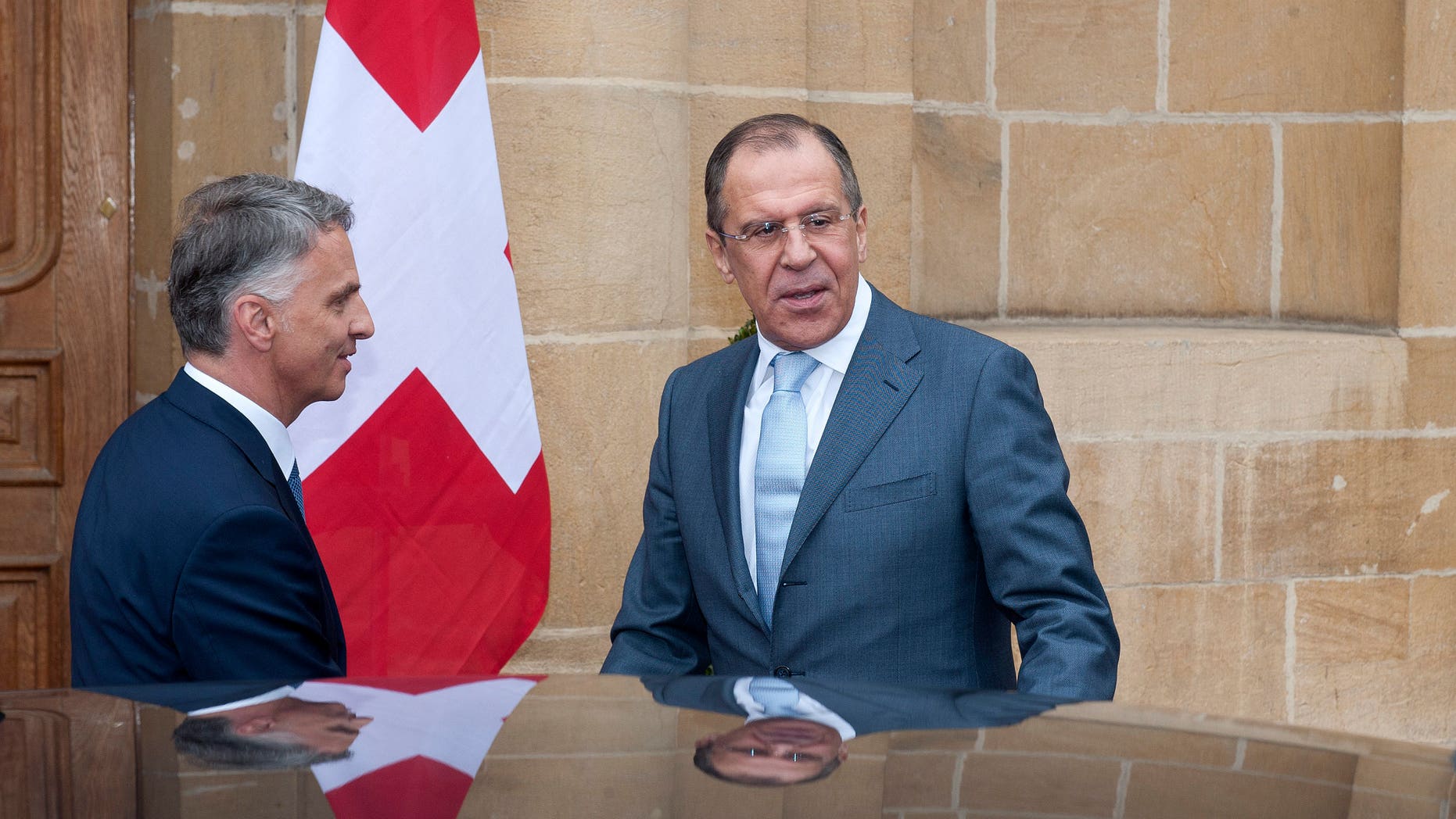Russian Foreign Minister Sergei Lavrov, right, is welcomed by Switzerland's Federal Councillor and Foreign Minister Didier Burkhalter, left, for a working visit a Neuchatel, Switzerland, Friday, April 12, 2013. (AP Photo/Keystone/Sandro Campardo)