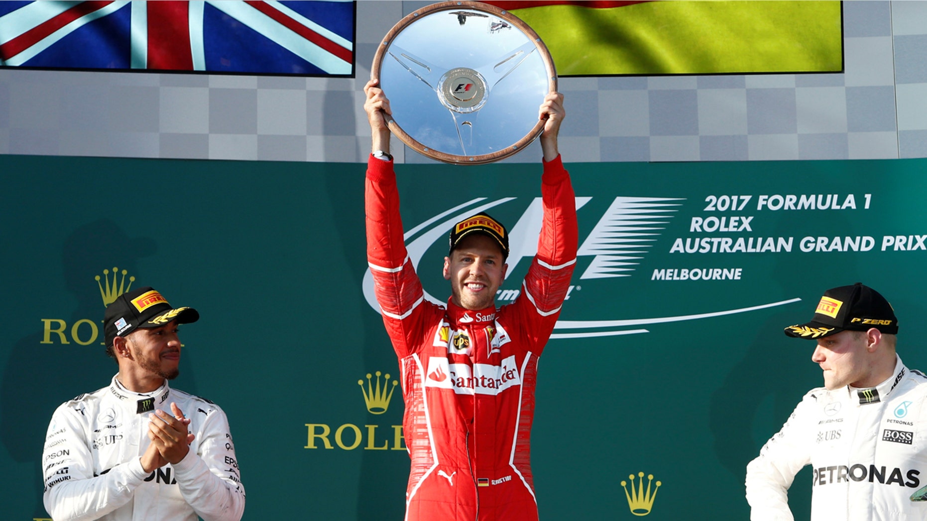 Formula One - F1 - Australian Grand Prix - Melbourne, Australia - 26/03/2017 - Ferrari driver Sebastian Vettel of Germany (C) celebrates alongside Mercedes driver Lewis Hamilton of Britain (L) and team mate Valtteri Bottas of Finland. REUTERS/Brandon Malone TPX IMAGES OF THE DAY - RTX32QM8