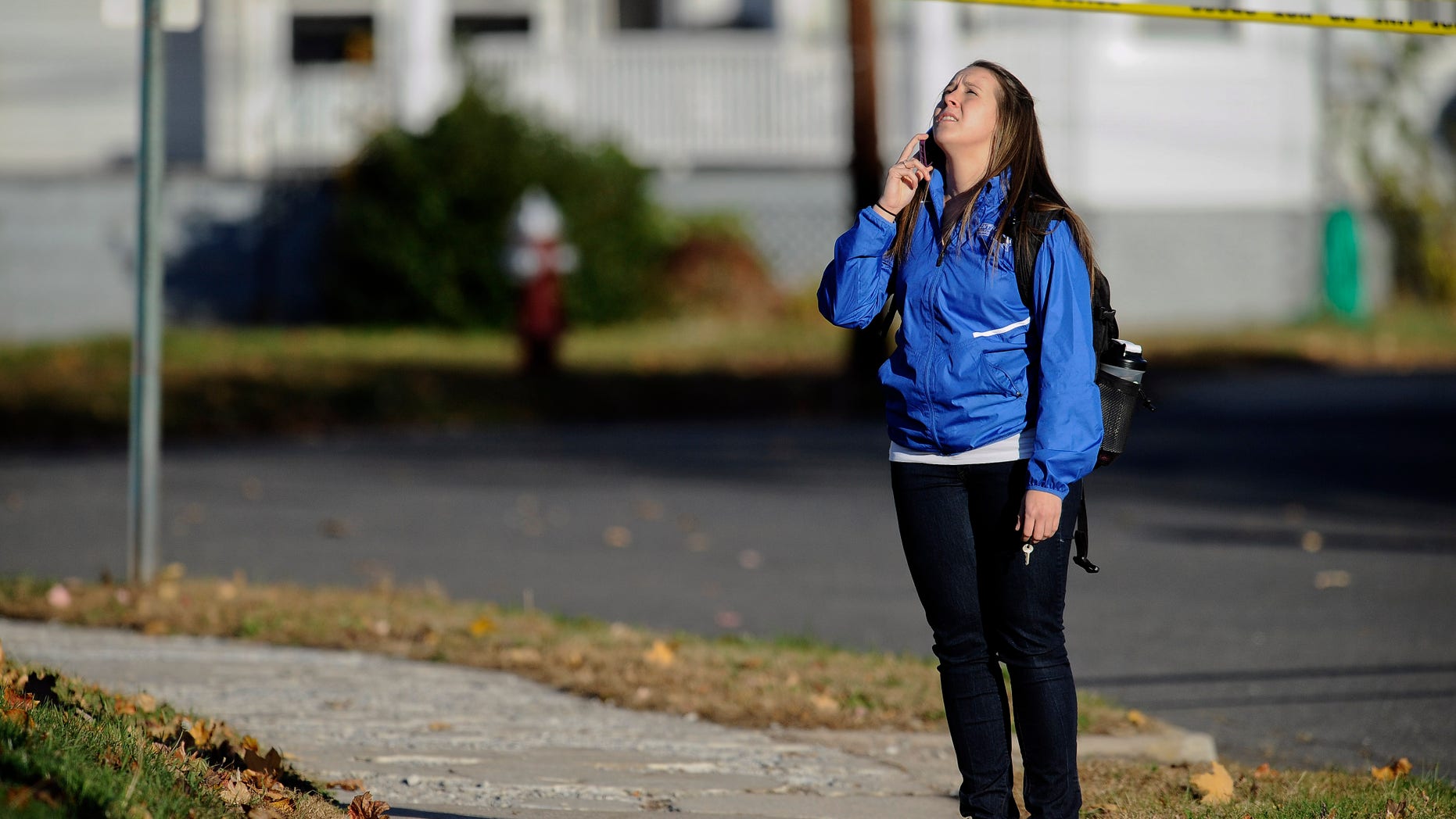 A student waits to return to campus following a lockdown due to a sighting of an armed man at Central Connecticut State University, Monday, Nov. 4, 2013, in New Britain, Conn. Officials say one person is in custody. (AP Photo/Jessica Hill)