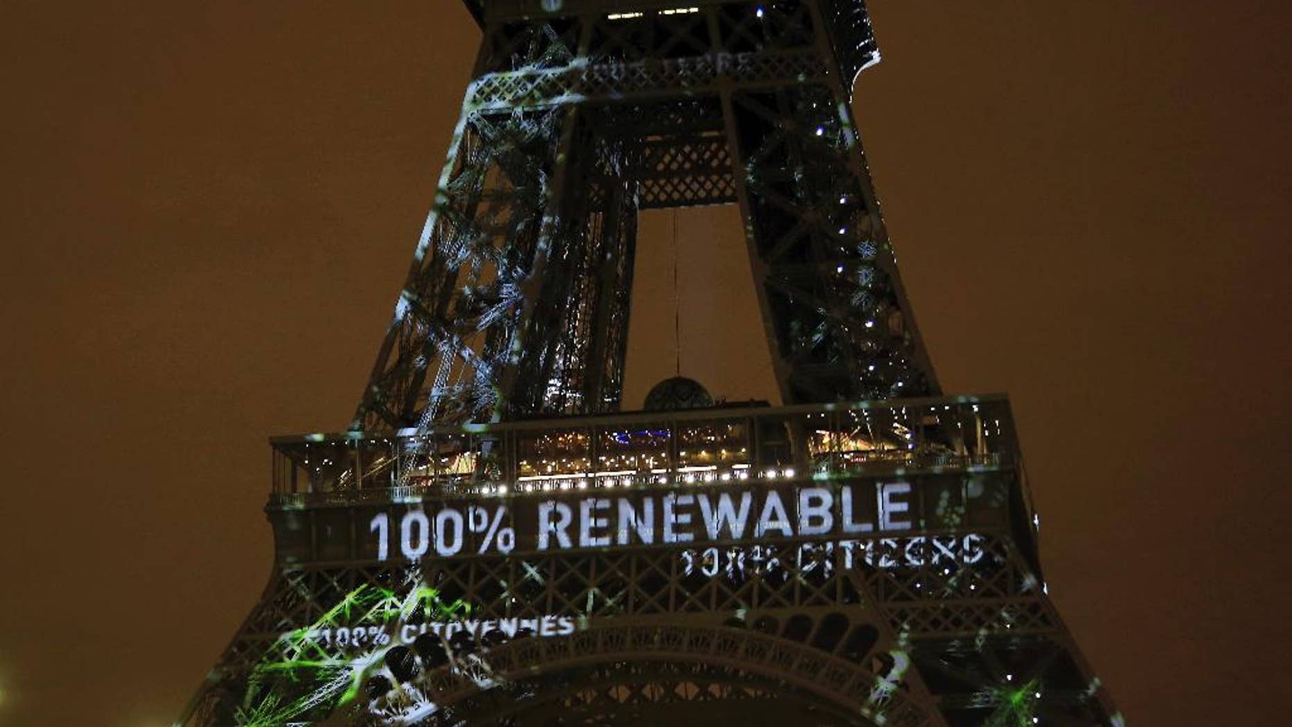 FILE- In this Sunday, Nov. 29, 2015 file photo, an artwork entitled 'One Heart One Tree' by artist Naziha Mestaoui is displayed on the Eiffel tower ahead of the 2015 Paris Climate Conference, in Paris. The Paris Agreement on climate change comes into force Friday Nov. 4, 2016, after a year with remarkable success in international efforts to slash man-made emissions of carbon dioxide and other global warming gases. (AP Photo/Thibault Camus, FILE)