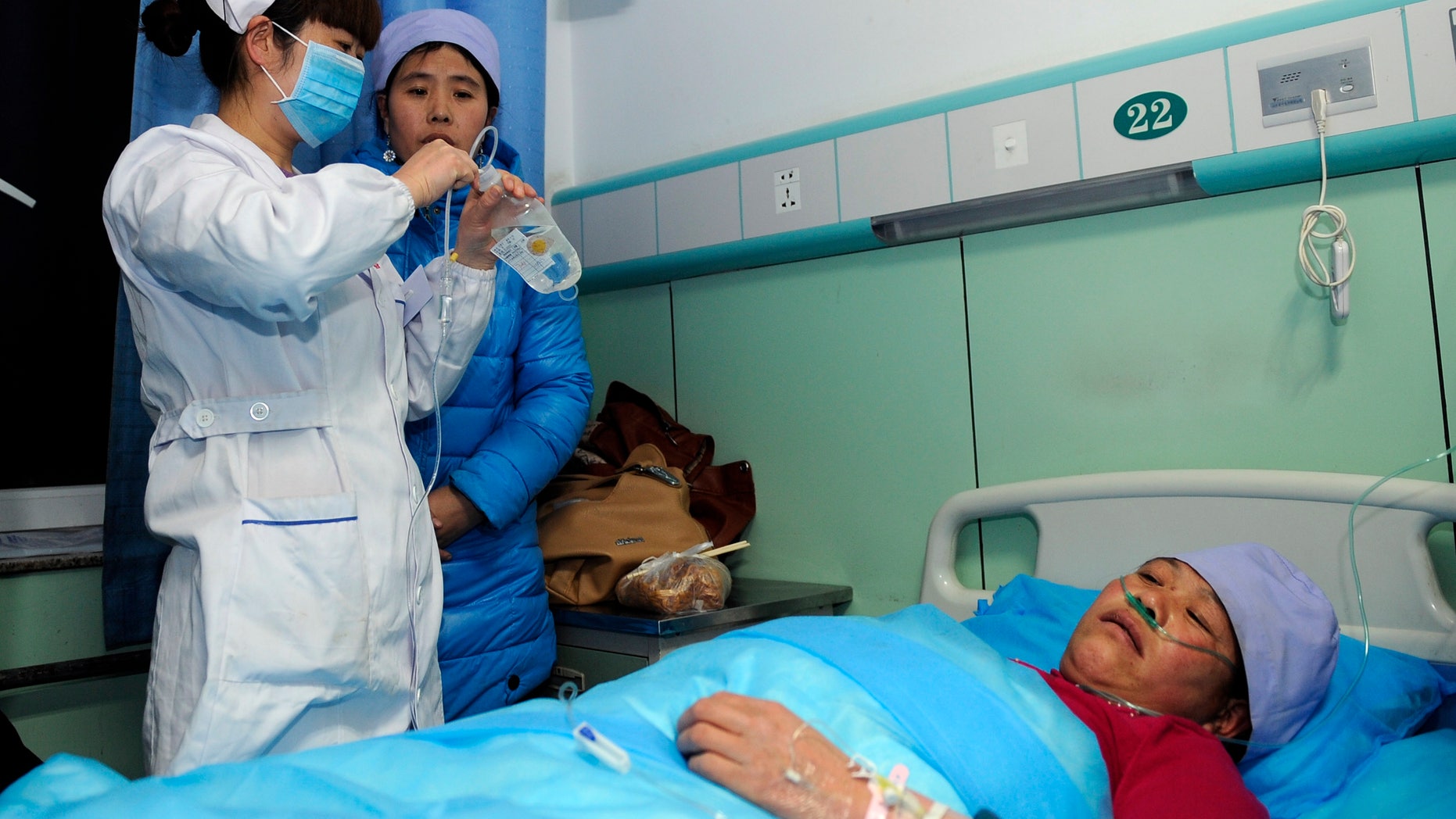 In this Sunday, Jan. 5, 2014 photo provided China's official Xinhnua News Agency, an injured woman receives medical treatment at a hospital in Xiji Town of Guyuan, northwest China's Ningxia region. China's Xinhua News Agency said Monday, Jan. 6, 14 people were killed in a stampede at a mosque in the country’s north and 10 other people were injured in the incident in Guyuan. (AP Photo/Xinhua, Li Ran) NO SALES