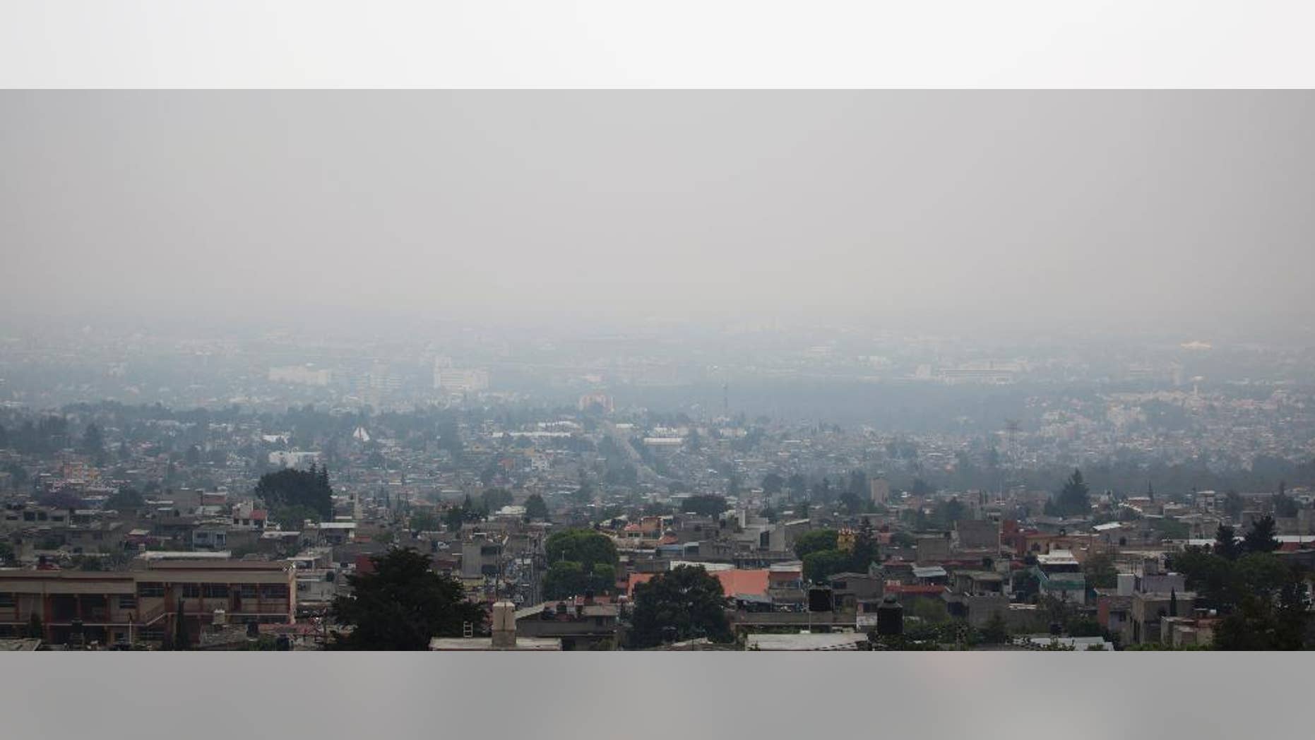 Air pollution hangs over Mexico City, Tuesday, May 3, 2016. Mexico City authorities have declared a new pollution alert and will require 40 percent of cars to keep off the streets. (AP Photo/Eduardo Verdugo)