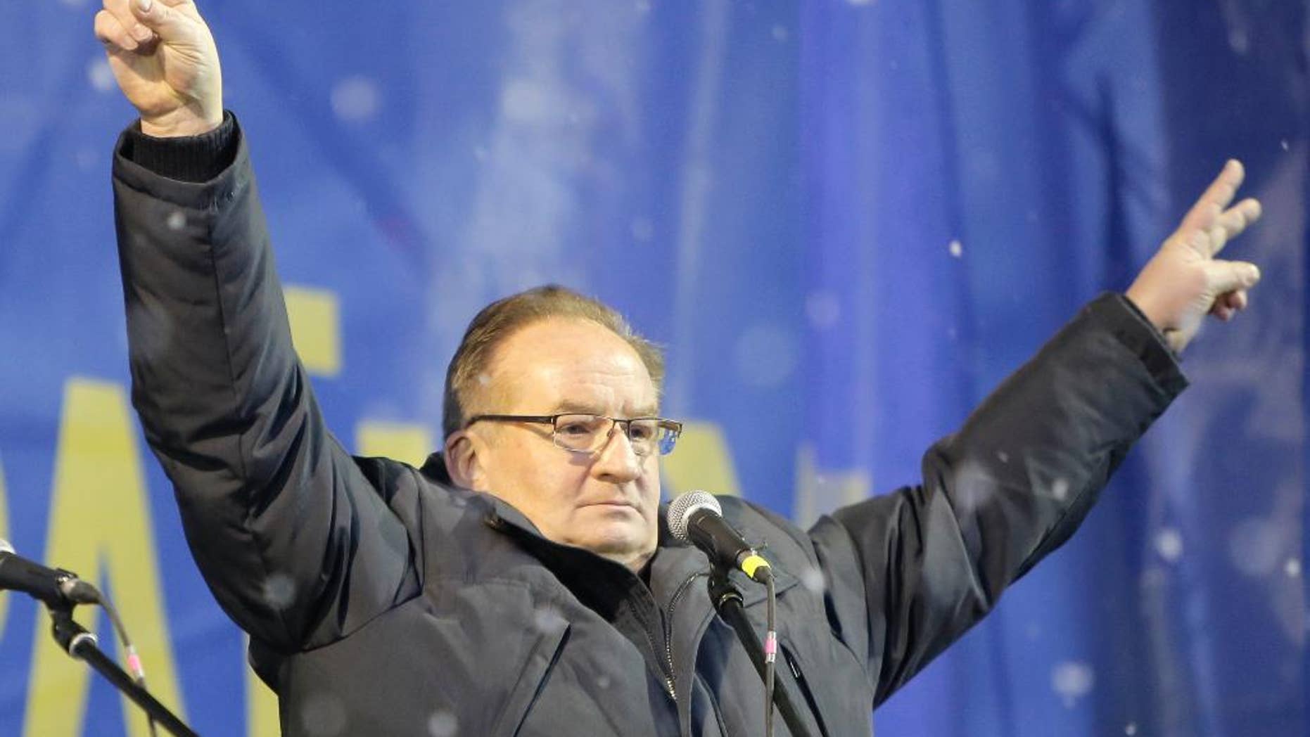 FILE - In this Dec. 7, 2013 file photo, Jacek Saryusz-Wolski, vice president of the European People's Party and chairman of the European People's Party Group, cheers pro-European Union supporters at a mass rally in the Independence Square as snow falls in Kiev, Ukraine. Saryusz-Wolski is Poland's surprise counter-candidate to challenge incumbent Donald Tusk for the post of European Council head. (AP Photo/Efrem Lukatsky, File)