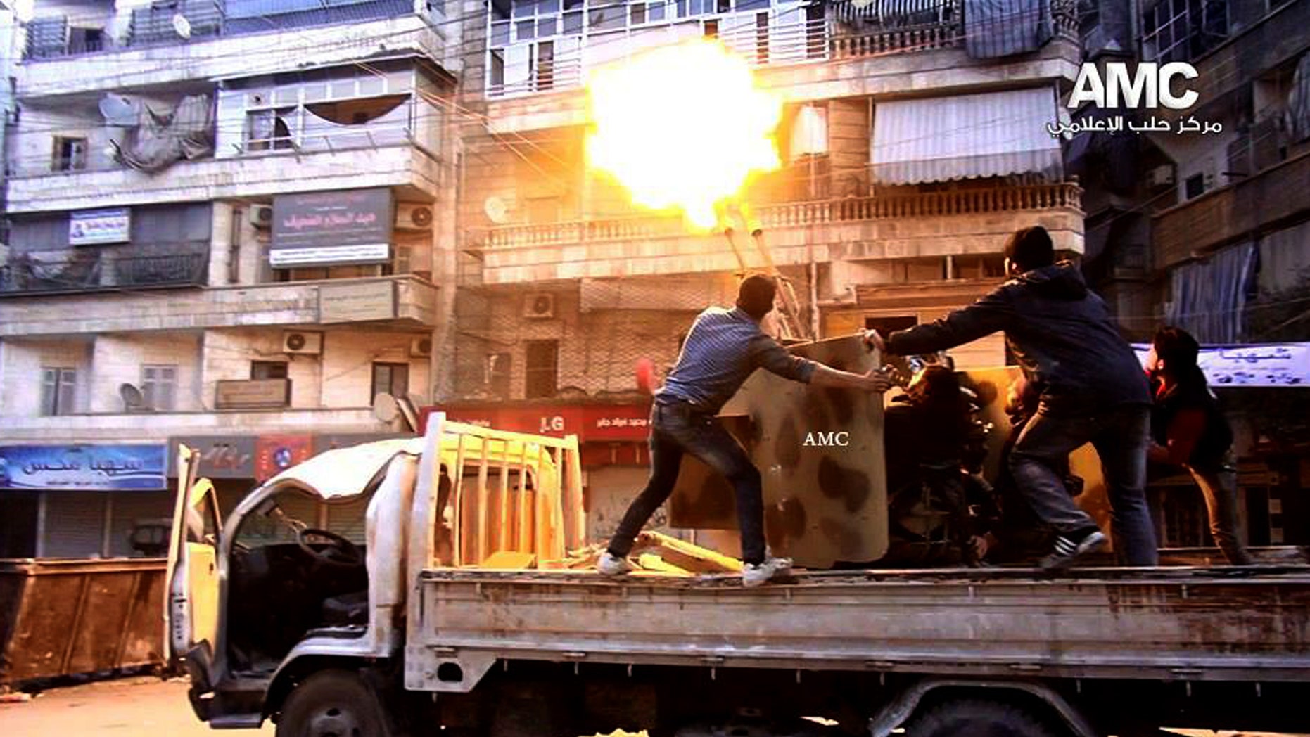 In this Saturday Feb. 1, 2014, photo provided by the anti-government activist group Aleppo Media Center (AMC), which has been authenticated based on its contents and other AP reporting, Syrian rebels fire their anti-aircraft gun at Syrian forces airplanes in Aleppo, Syria. Syrian government helicopters and warplanes unleashed a wave of airstrikes on more than a dozen opposition-held neighborhoods in the northern city of Aleppo on Sunday, in a ferocious attack that killed at least 36 people, including 17 children, activists said. The AMC logo has been inserted in top right corner and the initials AMC appear on weapon. (AP Photo/Aleppo Media Center, AMC)