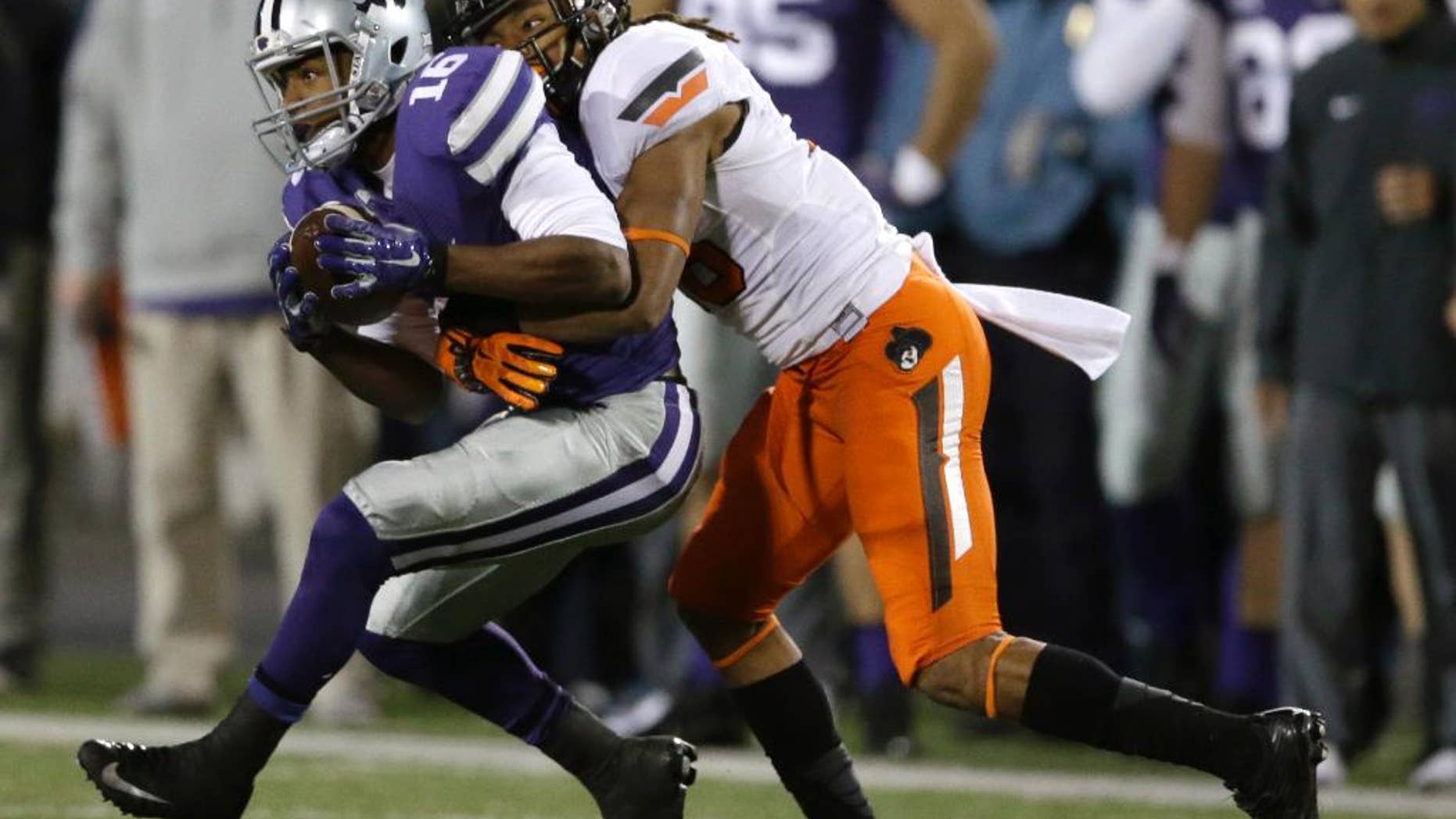 Kansas State wide receiver Tyler Lockett (16) is tackled by Oklahoma State cornerback Ramon Richards (18) during the first half of an NCAA college football game in Manhattan, Kan., Saturday, Nov. 1, 2014. (AP Photo/Orlin Wagner)