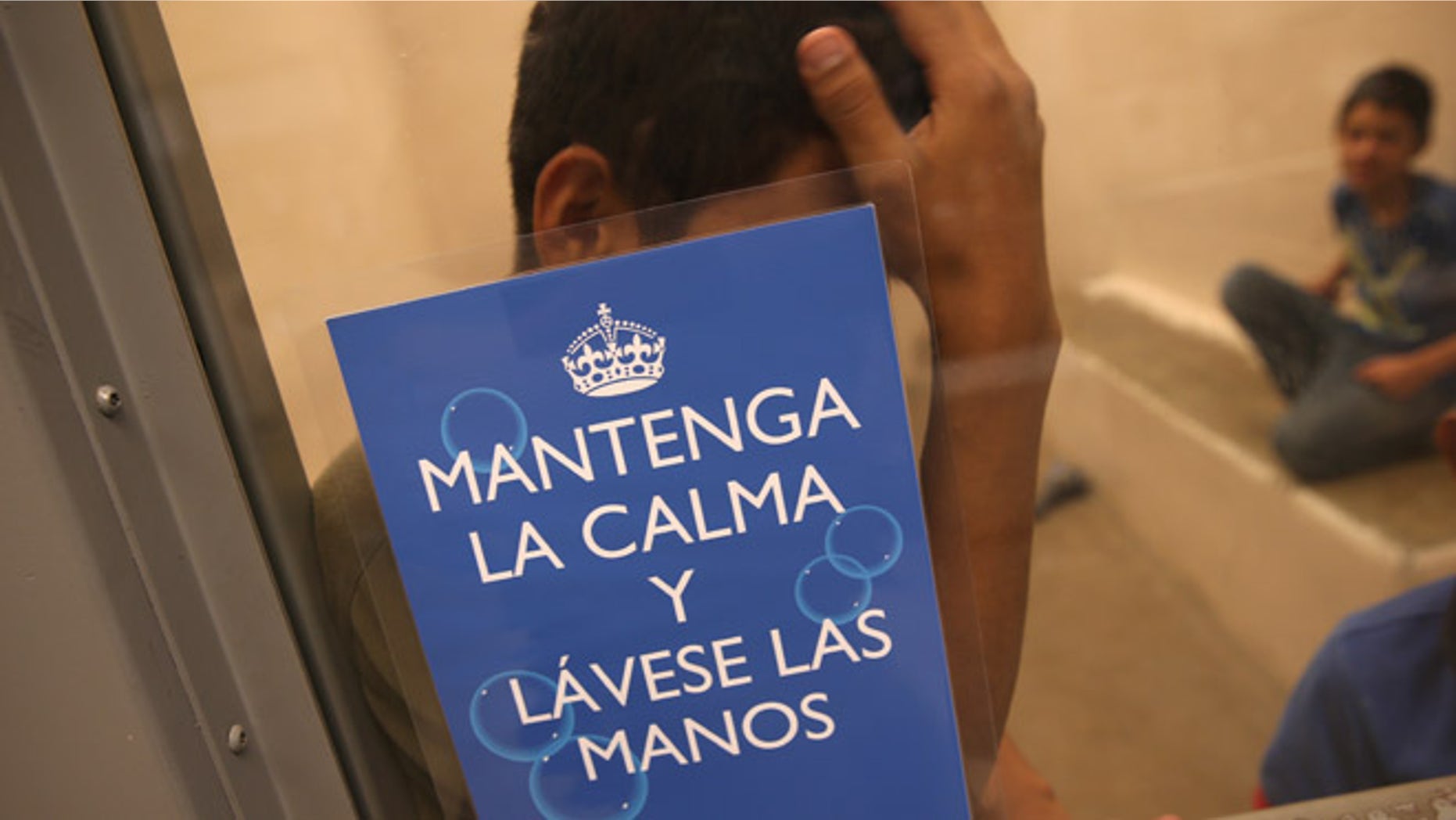 MCALLEN, TX - SEPTEMBER 08: Junvenile immigrants wait in a holding cell at a U.S. Border Patrol processing center for immigrants detained near the U.S.-Mexico border on September 8, 2014 in McAllen, Texas. The sign, written by the U.S. Centers for Disease Control (CDC), reads "Maintain Calm and Wash Your Hands." Thousands of immigrants, many of them families and unaccompanied minors, continue to cross illegally into the United States, although the numbers are down from a springtime high. Texas' Rio Grande Valley area is the busiest sector for illegal border crossings into the United States. (Photo by John Moore/Getty Images)