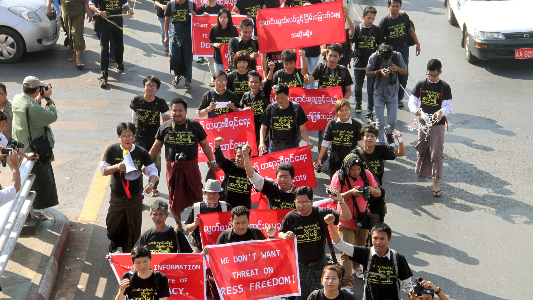 Myanmar journalists shout slogans while marching through Yangon, Tuesday, Jan. 7, 2014, in Myanmar. Dozens of journalists staged a rare demonstration in Myanmar's biggest city to protest against a jail term given to a colleague working on a corruption story. (AP Photo/Khin Maung Win)
