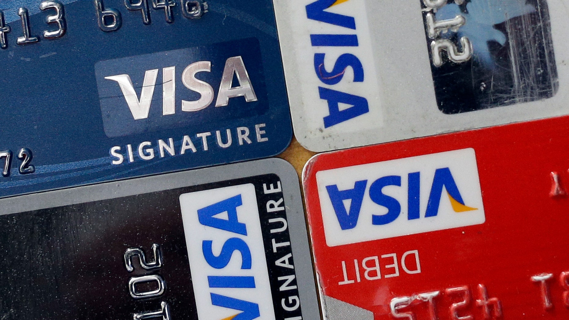 FILE - In this April 25, 2013 file photo, credit and debit cards are displayed for a photographer in Baltimore. Visa Inc. reports quarterly financial results after the market closes on Wednesday, Oct, 30, 2013. (AP Photo/Patrick Semansky, File)